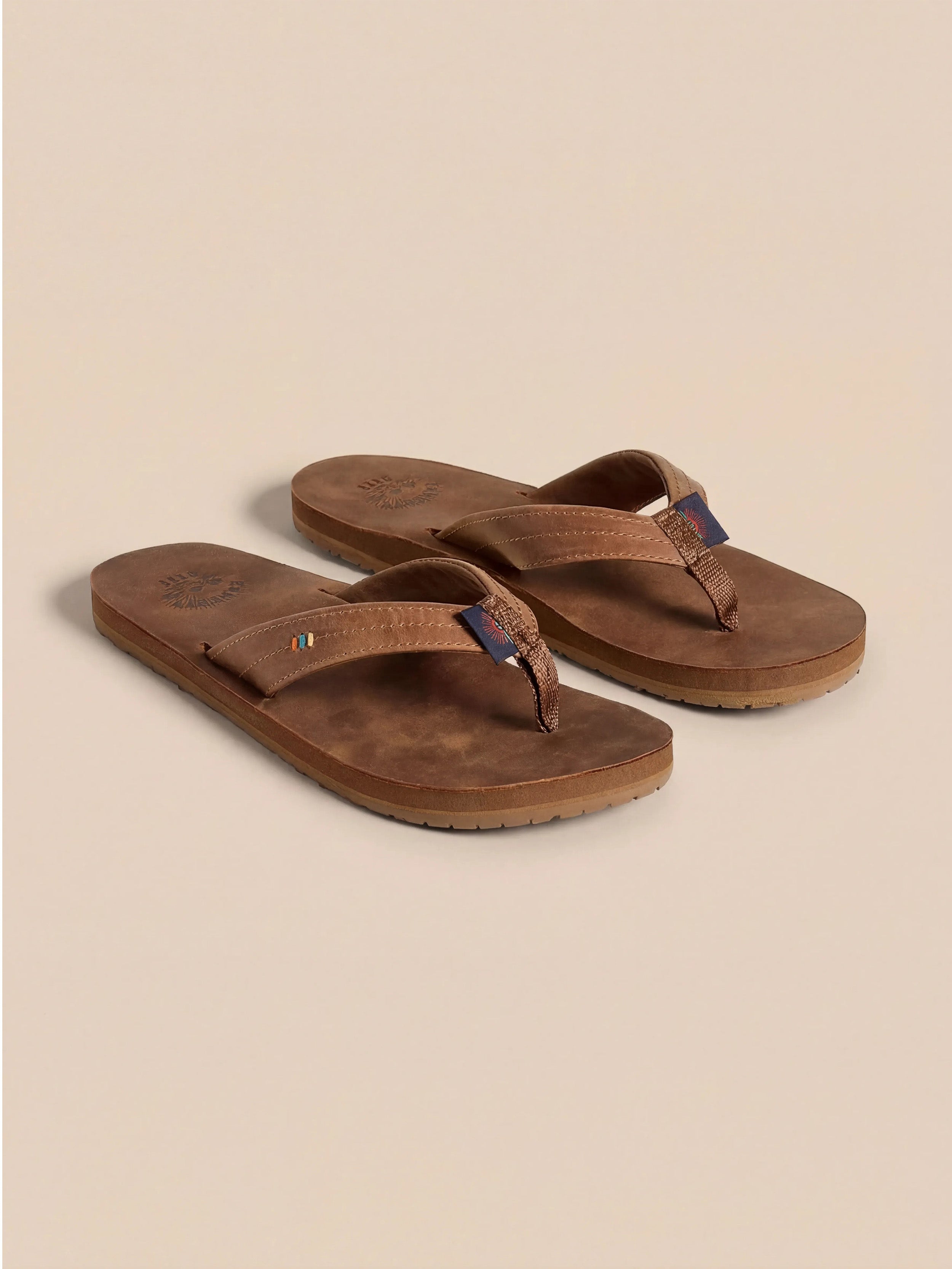 Pair of brown sandals on a beige background