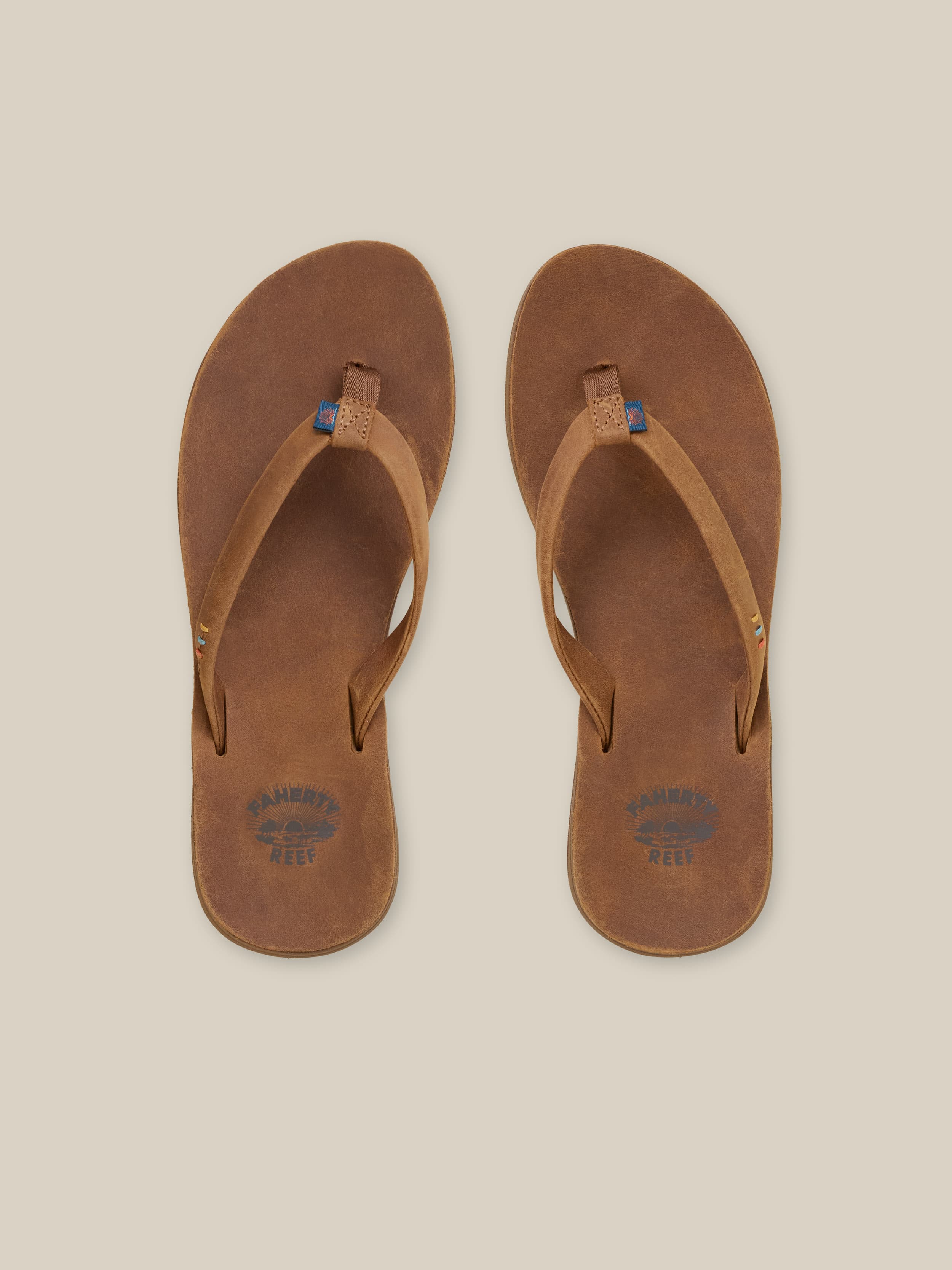 Pair of brown sandals on a beige background