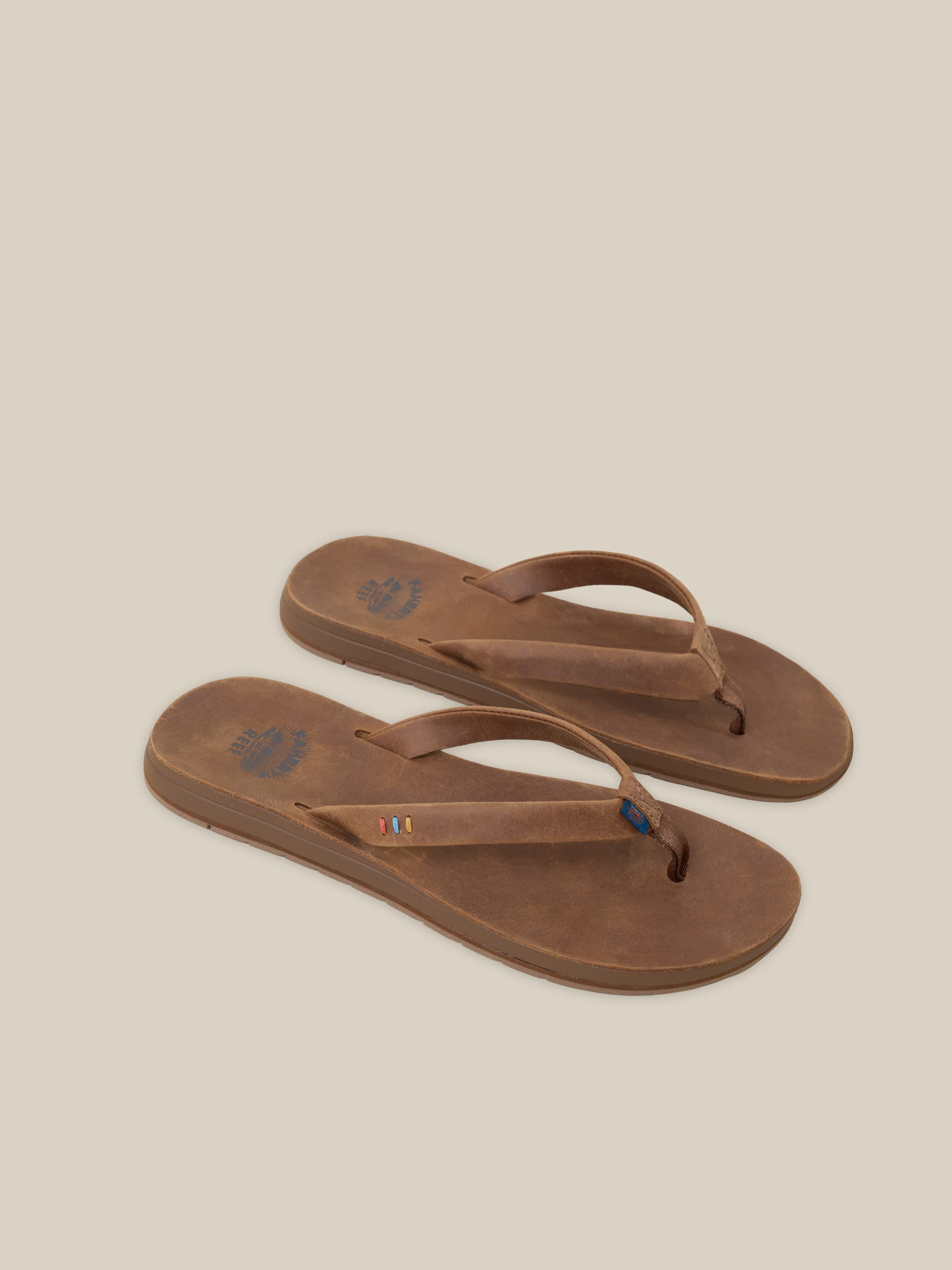 Pair of brown sandals on a beige background