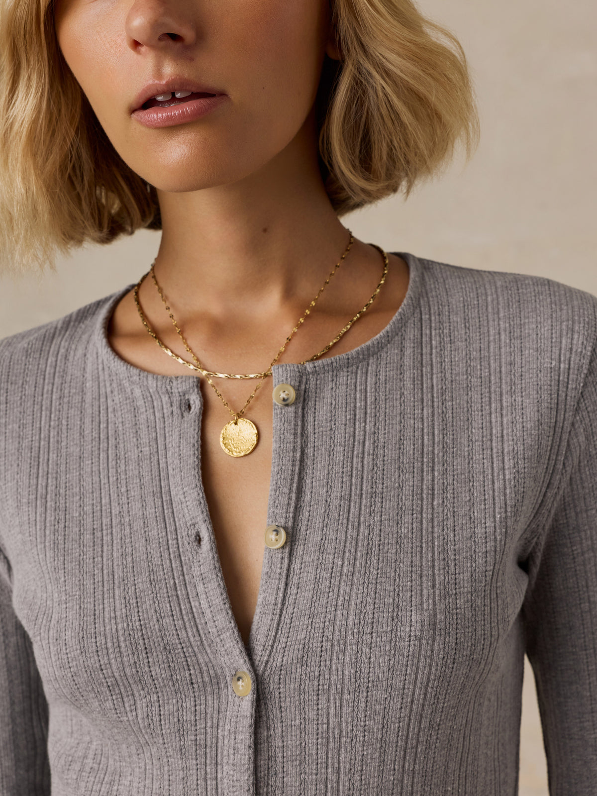 Close up of a woman wearing a grey cardigan, image 6 of 6