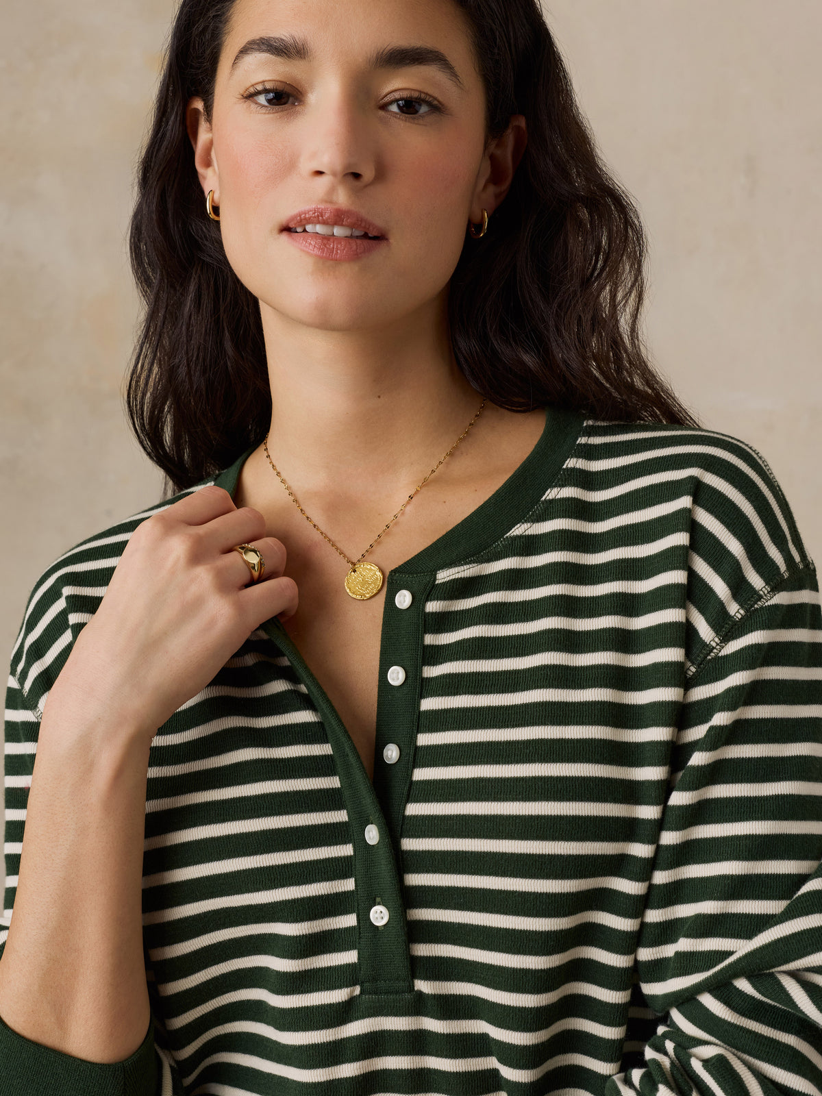 Close up of a woman wearing a green striped henley shirt, image 3 of 5