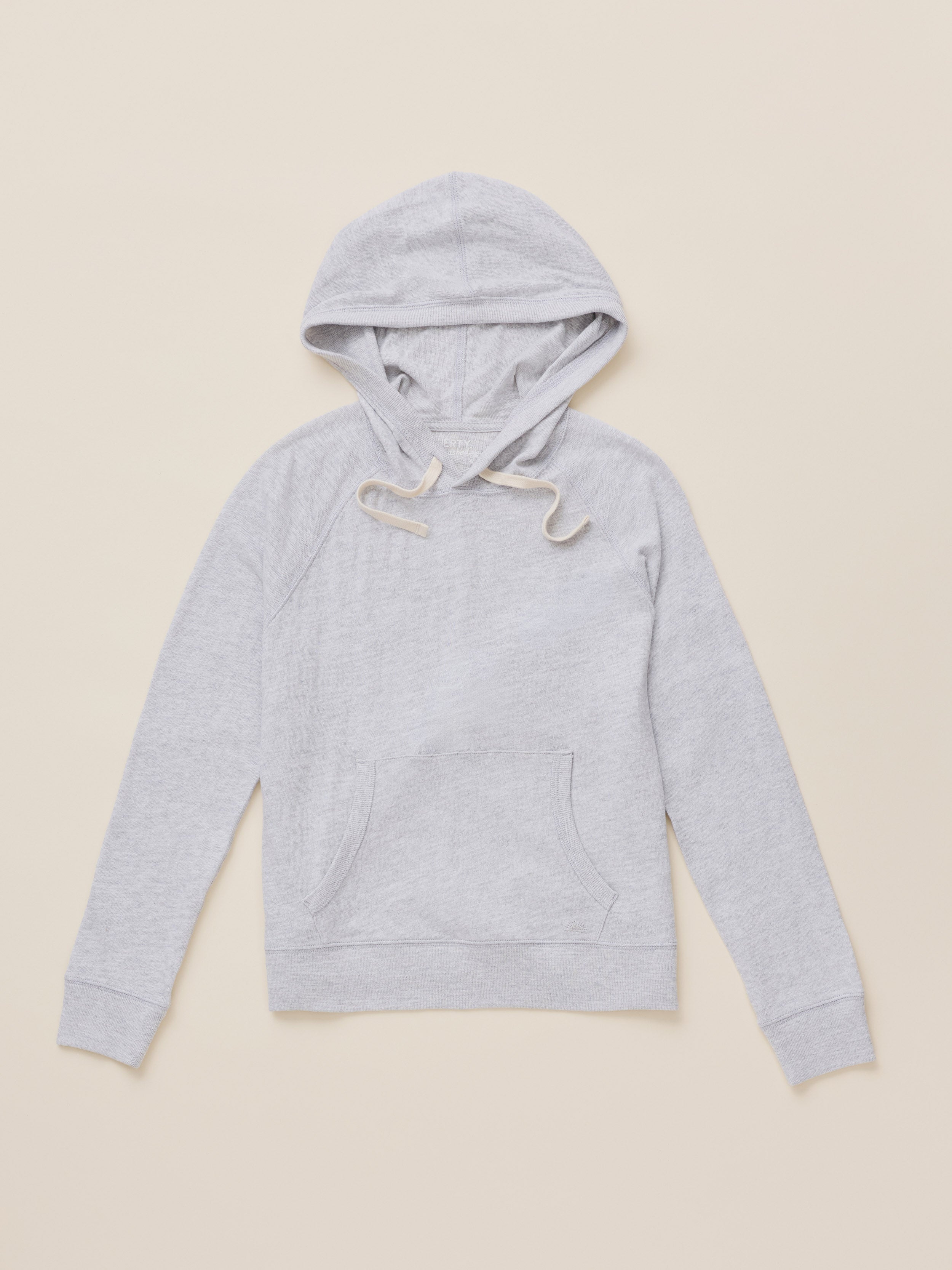 A light gray heather pullover hoodie with white drawstrings, laid flat against a solid beige background.