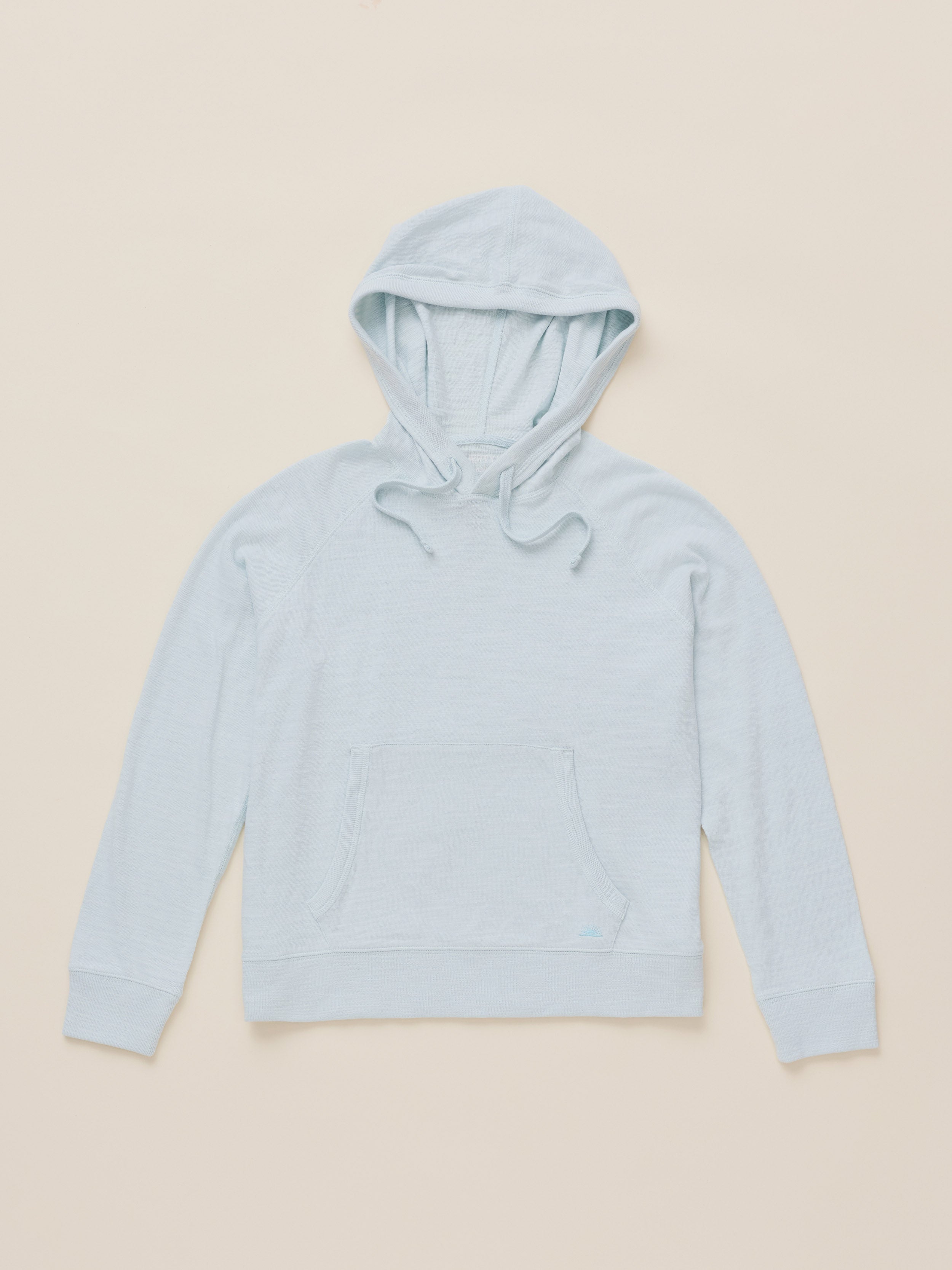 A light blue hooded sweatshirt with a front kangaroo pocket, laid flat on a warm beige background.