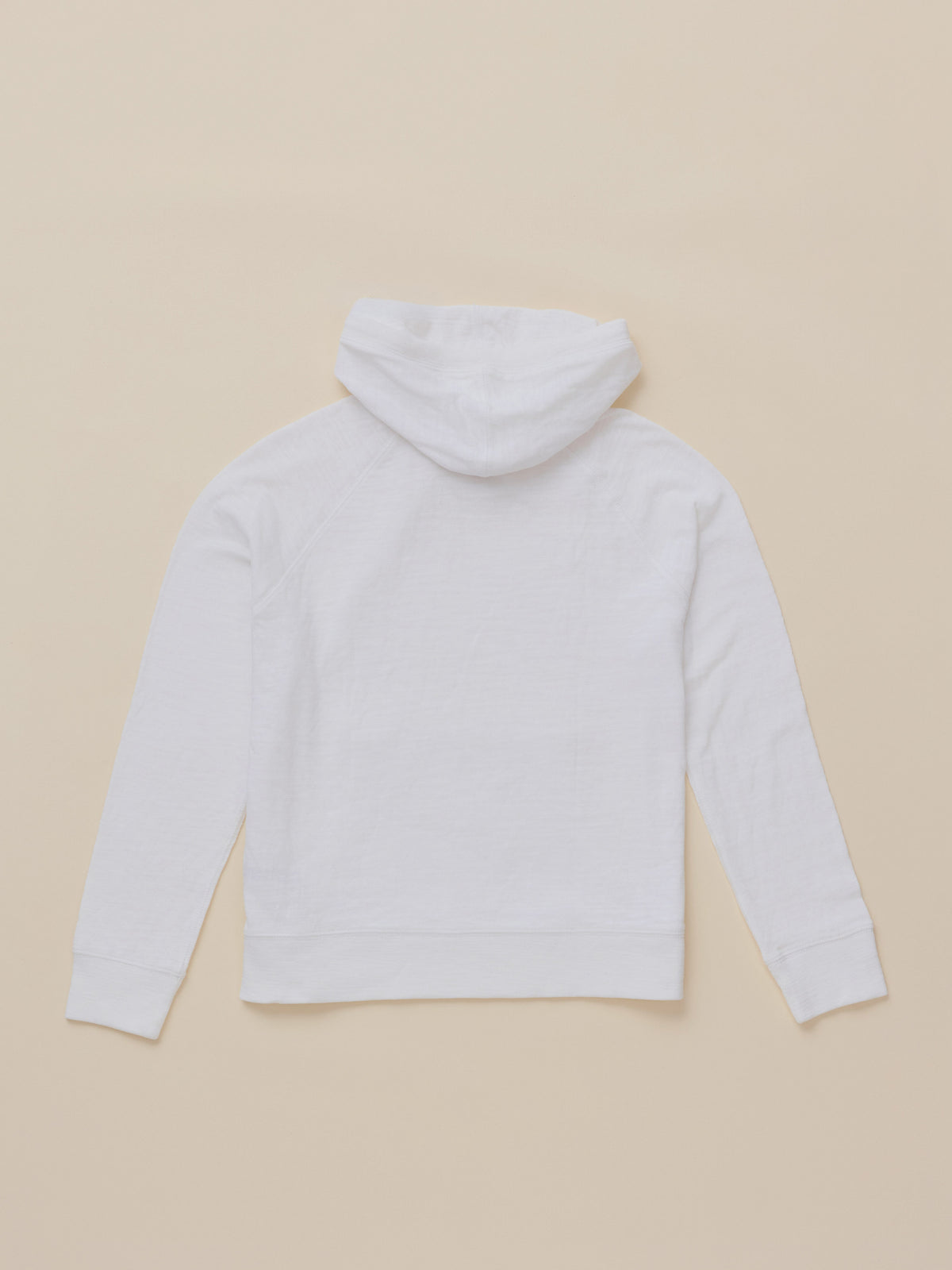 A white long-sleeve hoodie shown from the back, laid flat on a solid beige background.