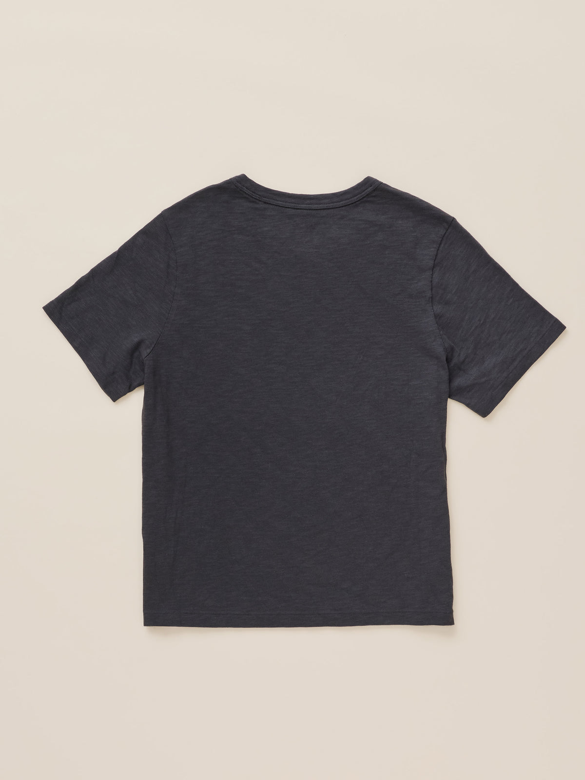 A dark charcoal gray short-sleeve t-shirt shown from the back, laid flat against a light beige background.