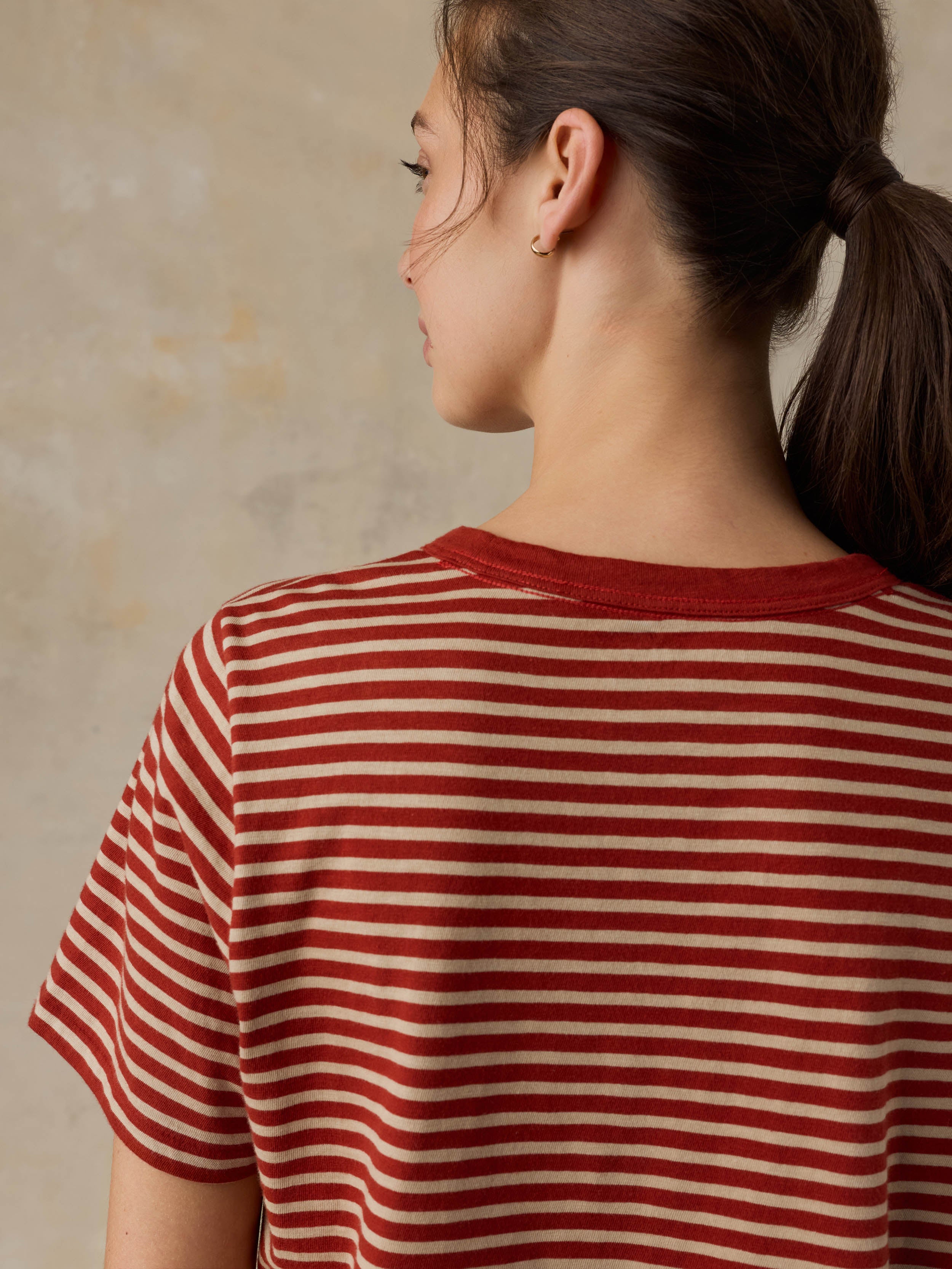 Woman wearing a red striped shirt against a beige background