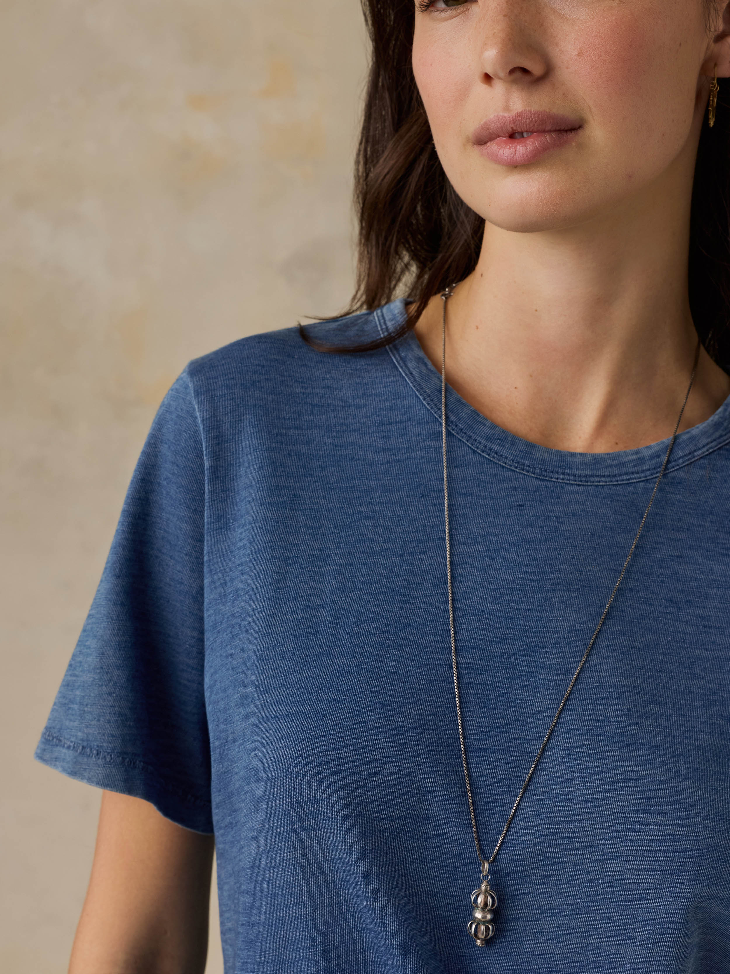 Woman wearing a blue t-shirt against a beige background