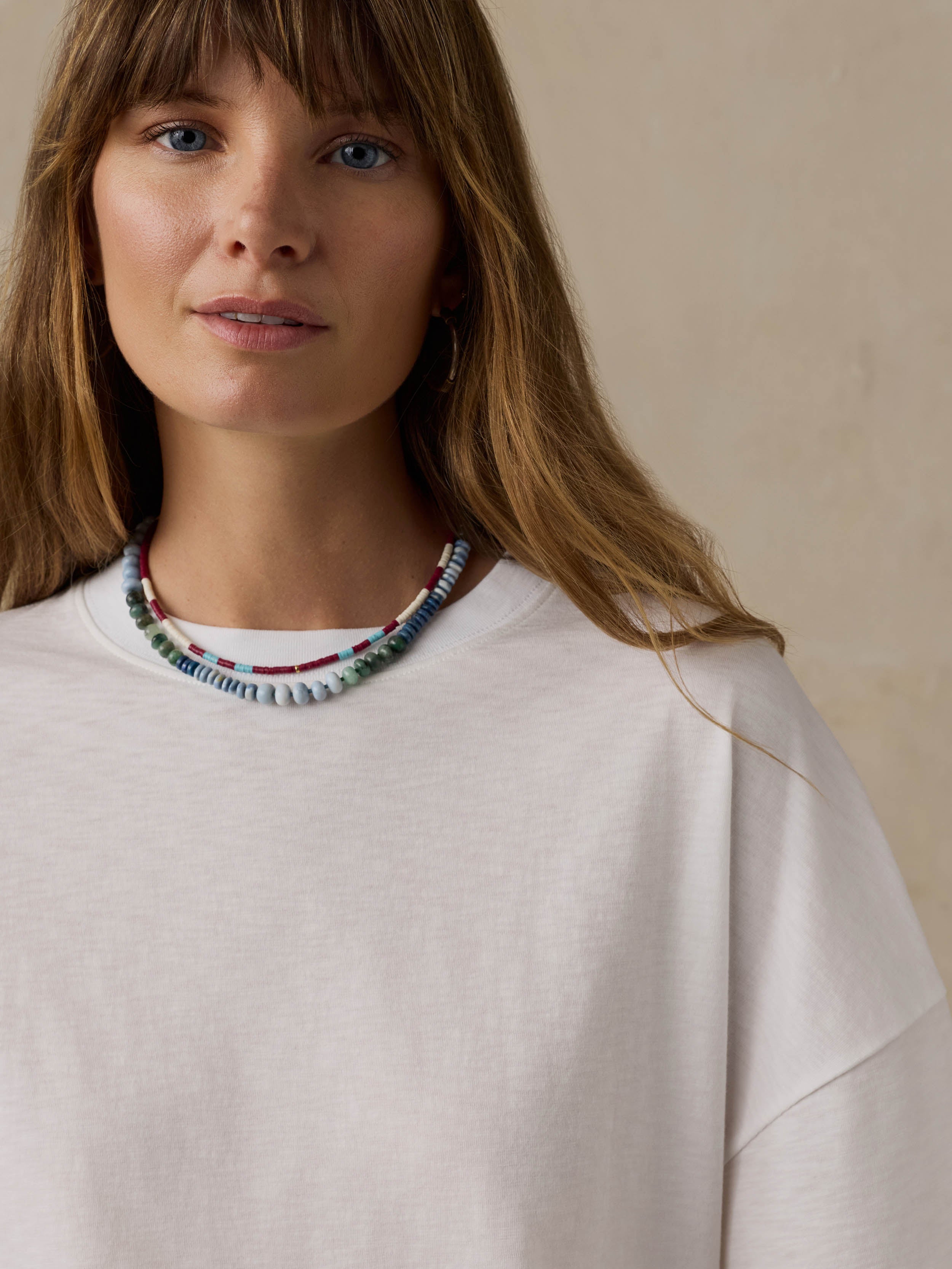 Woman wearing a white t-shirt against a beige background