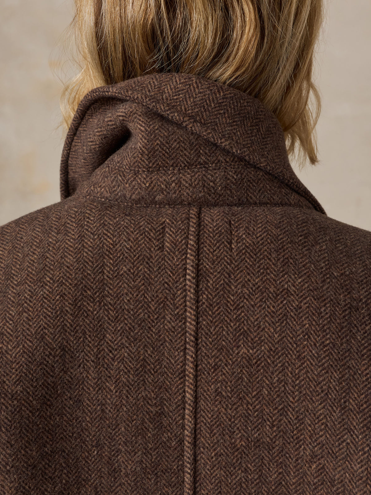 Close up of a woman viewed from the back wearing a brown coat, image 7 of 9