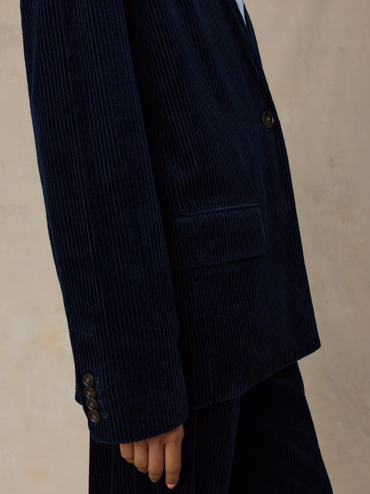 Close up of a woman wearing a dark navy blue corduroy suit, image 3 of 7