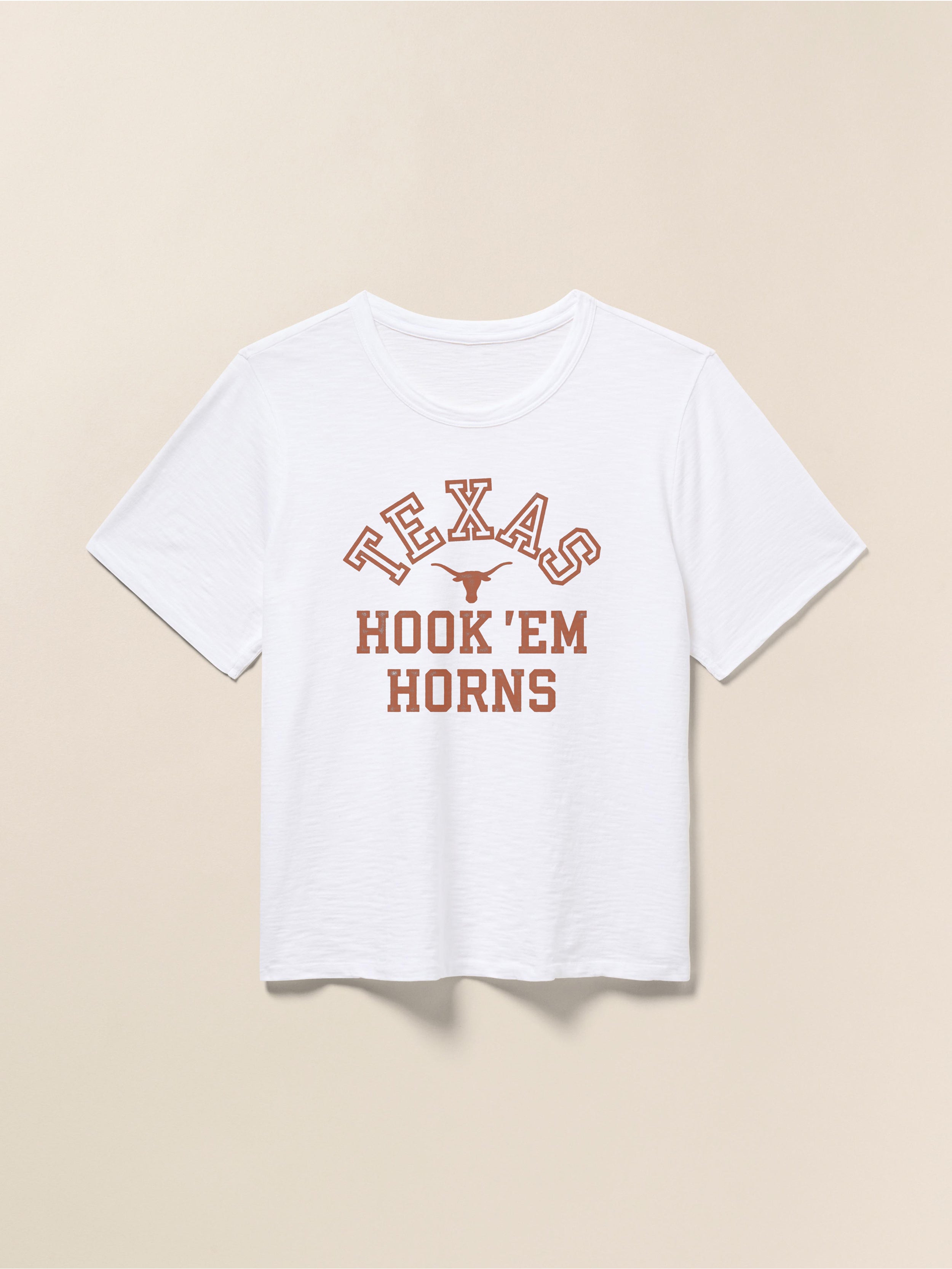White short sleeve t-shirt with UT Austin graphic on the center front against a beige background