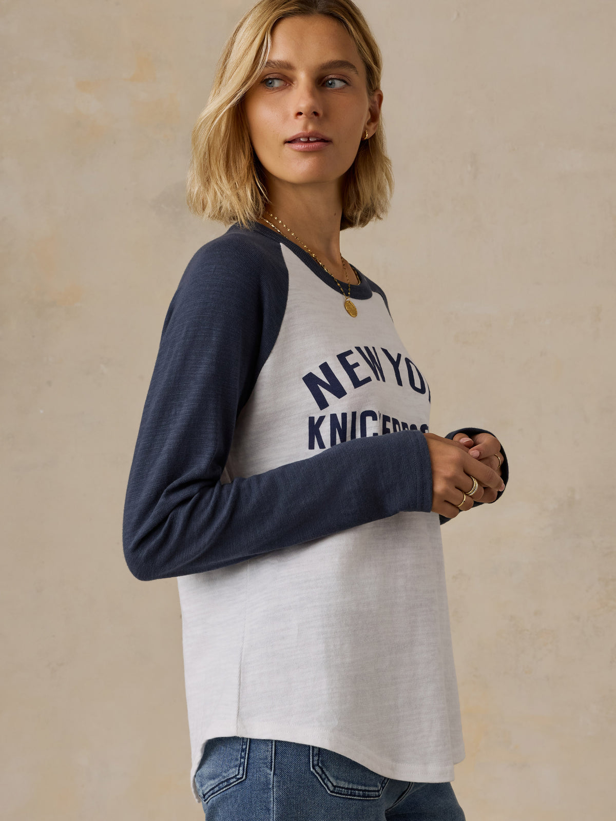 A woman wearing a blue and white NY Knicks baseball tee, image 4 of 6