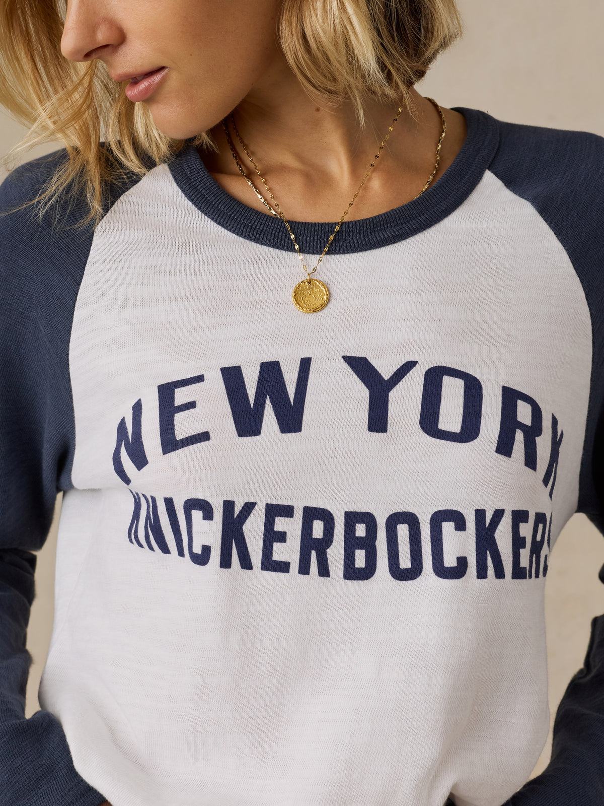 Close up of a woman wearing a blue and white NY Knicks baseball tee, image 2 of 6