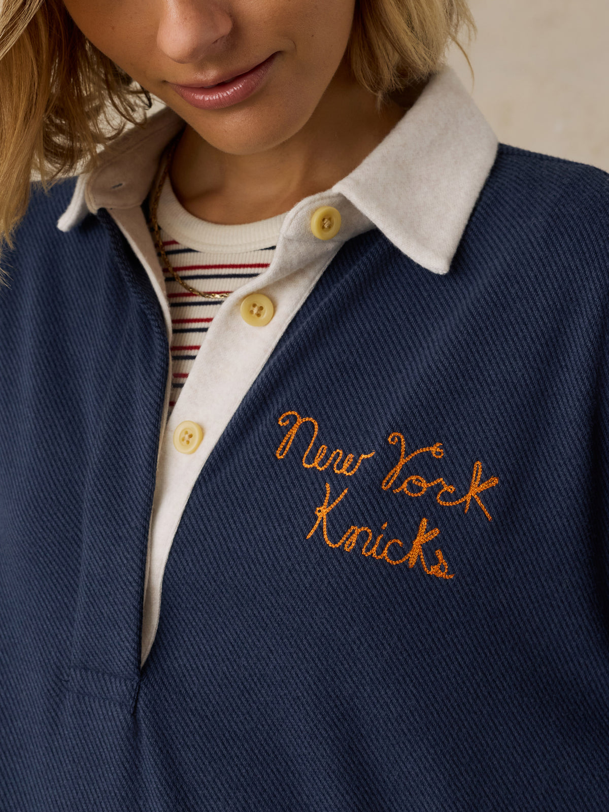 Close up of a woman wearing a navy NY Knicks rugby, image 3 of 6