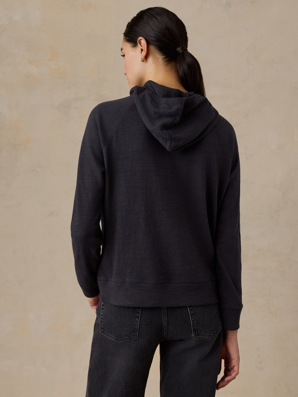 A woman viewed from behind wearing a black LA Lakers hoodie, image 3 of 5