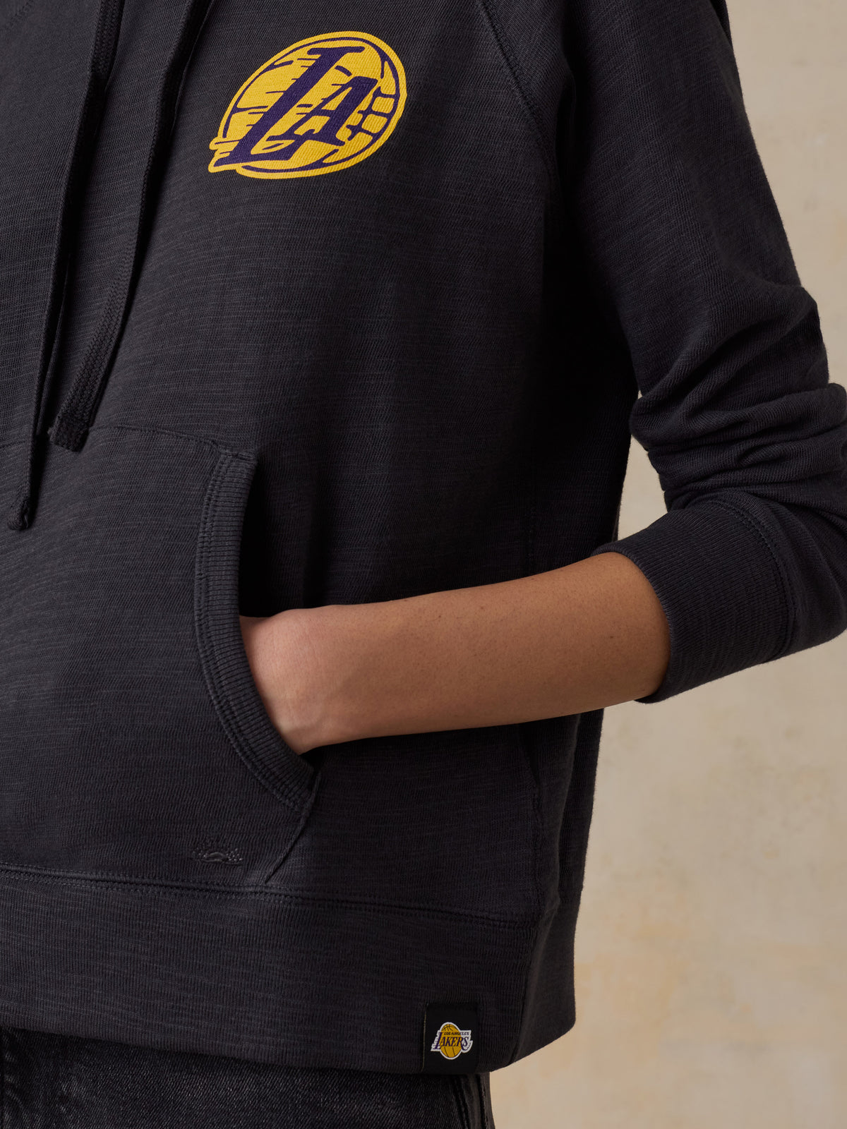 Close up of a woman wearing a black LA Lakers hoodie, image 4 of 5