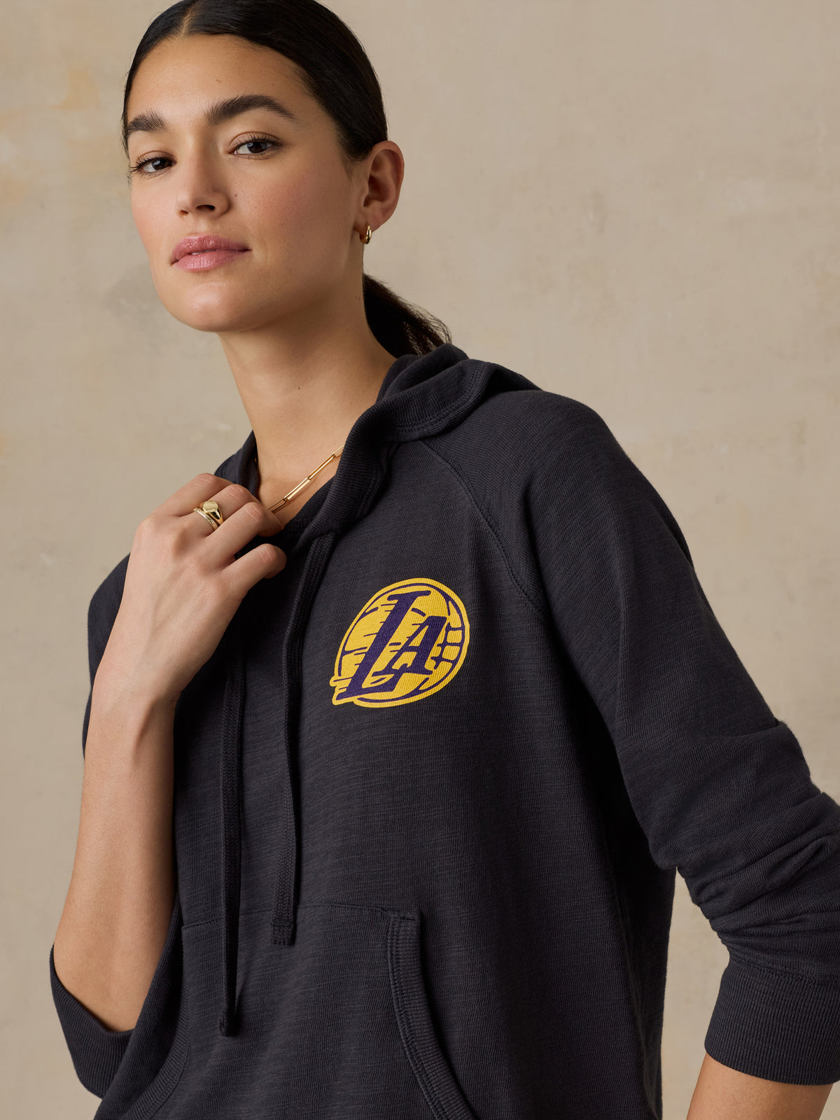 Close up of a woman wearing a black LA Lakers hoodie, image 2 of 5