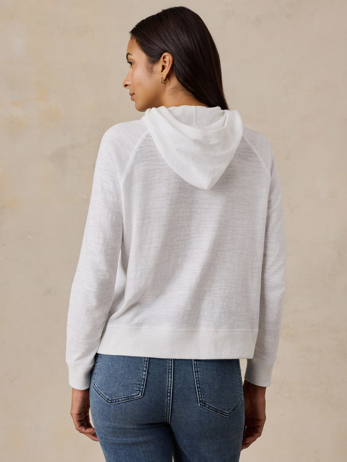 A woman viewed from behind wearing a white Chicago Bulls hoodie, image 3 of 5
