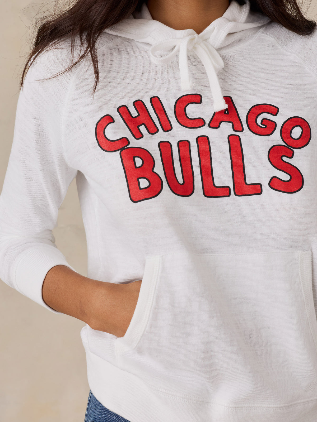 Close up of a woman wearing a white Chicago Bulls hoodie, image 2 of 5