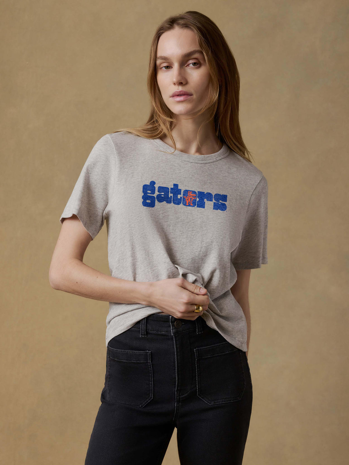 A woman wearing a grey University of Florida tee and black jeans, image 1 of 1