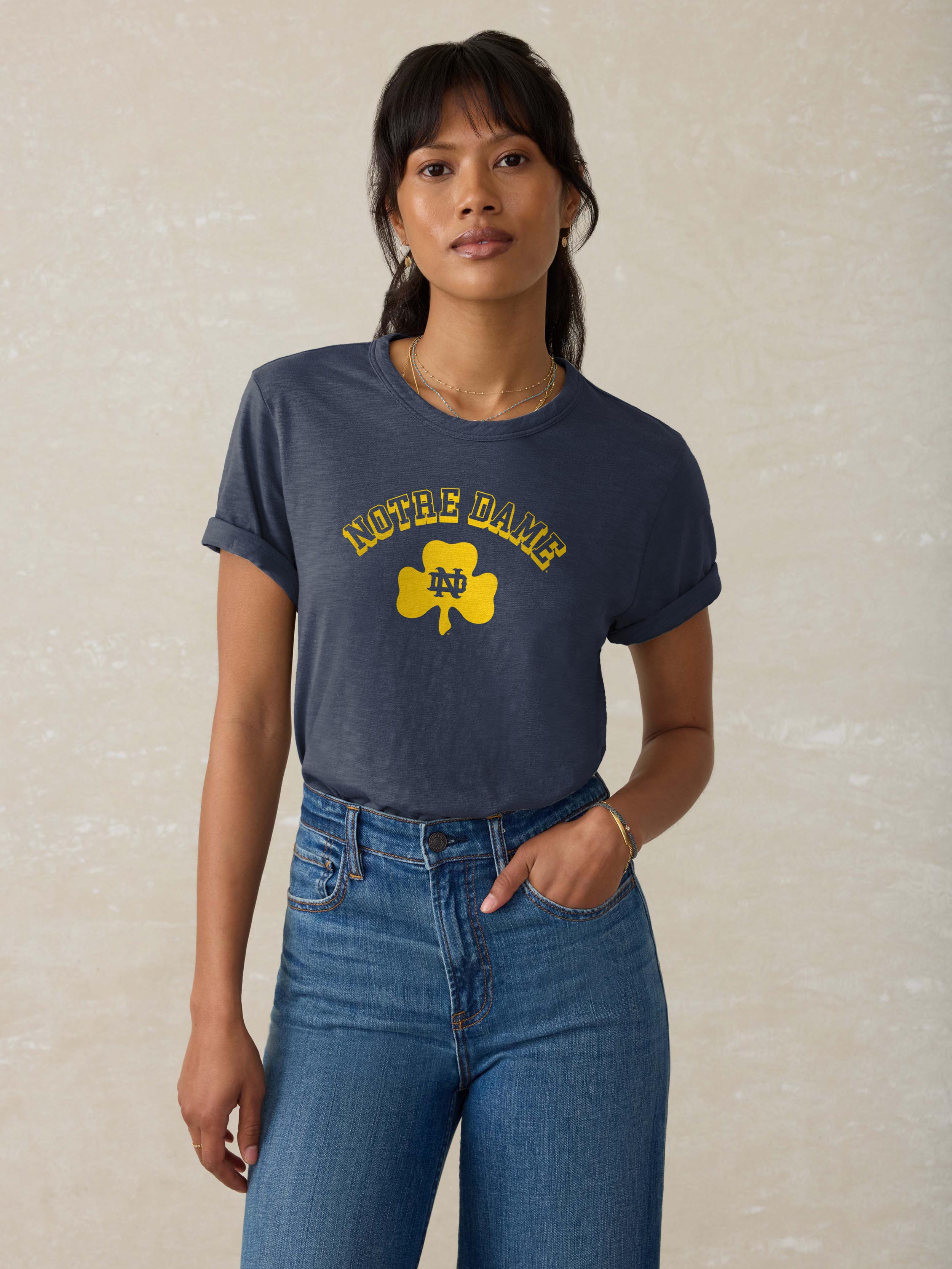 A woman wearing a blue Notre Dame tee and blue jeans