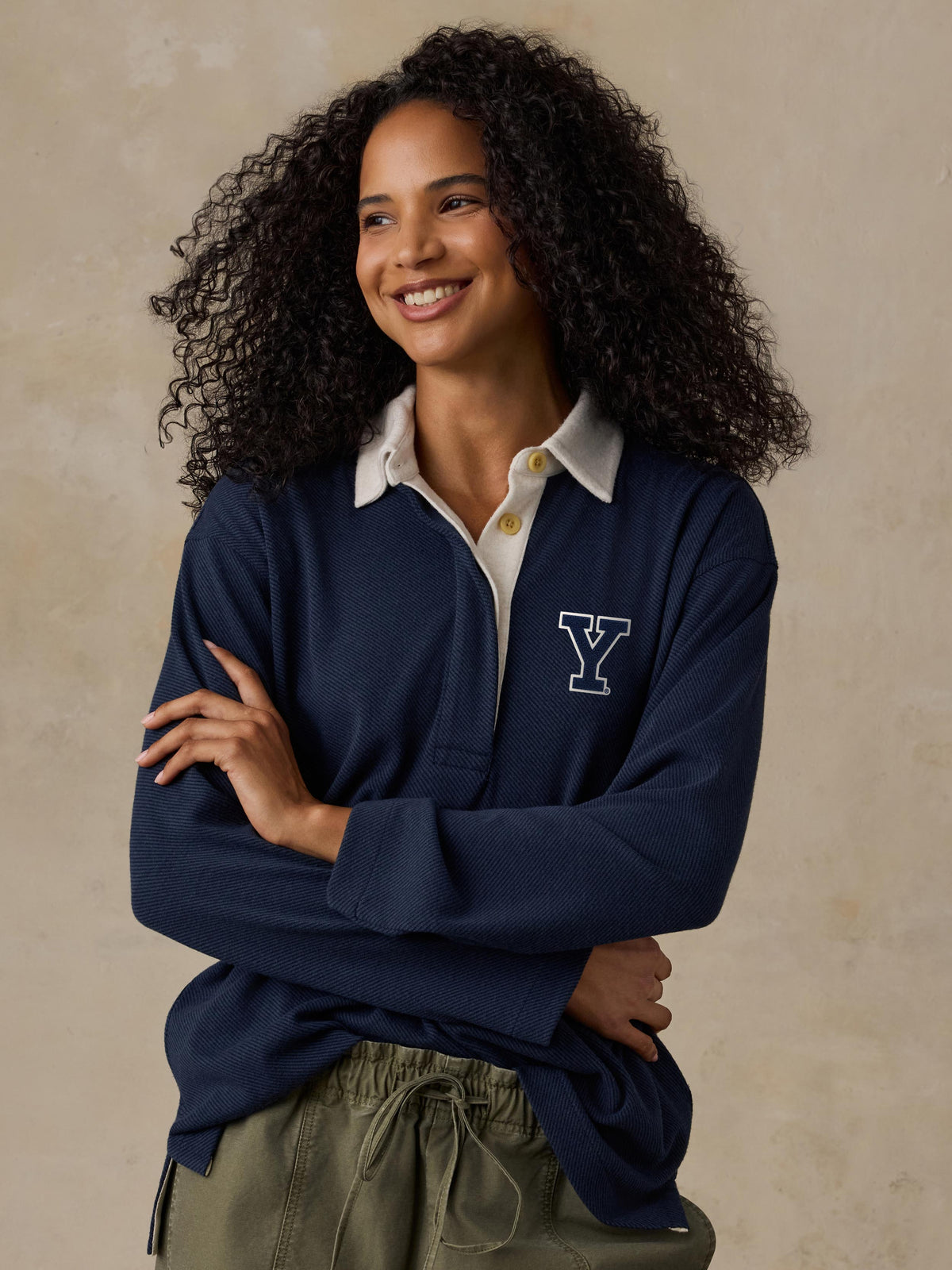 A woman wearing a blue Yale rugby shirt and green pants, image 1 of 1