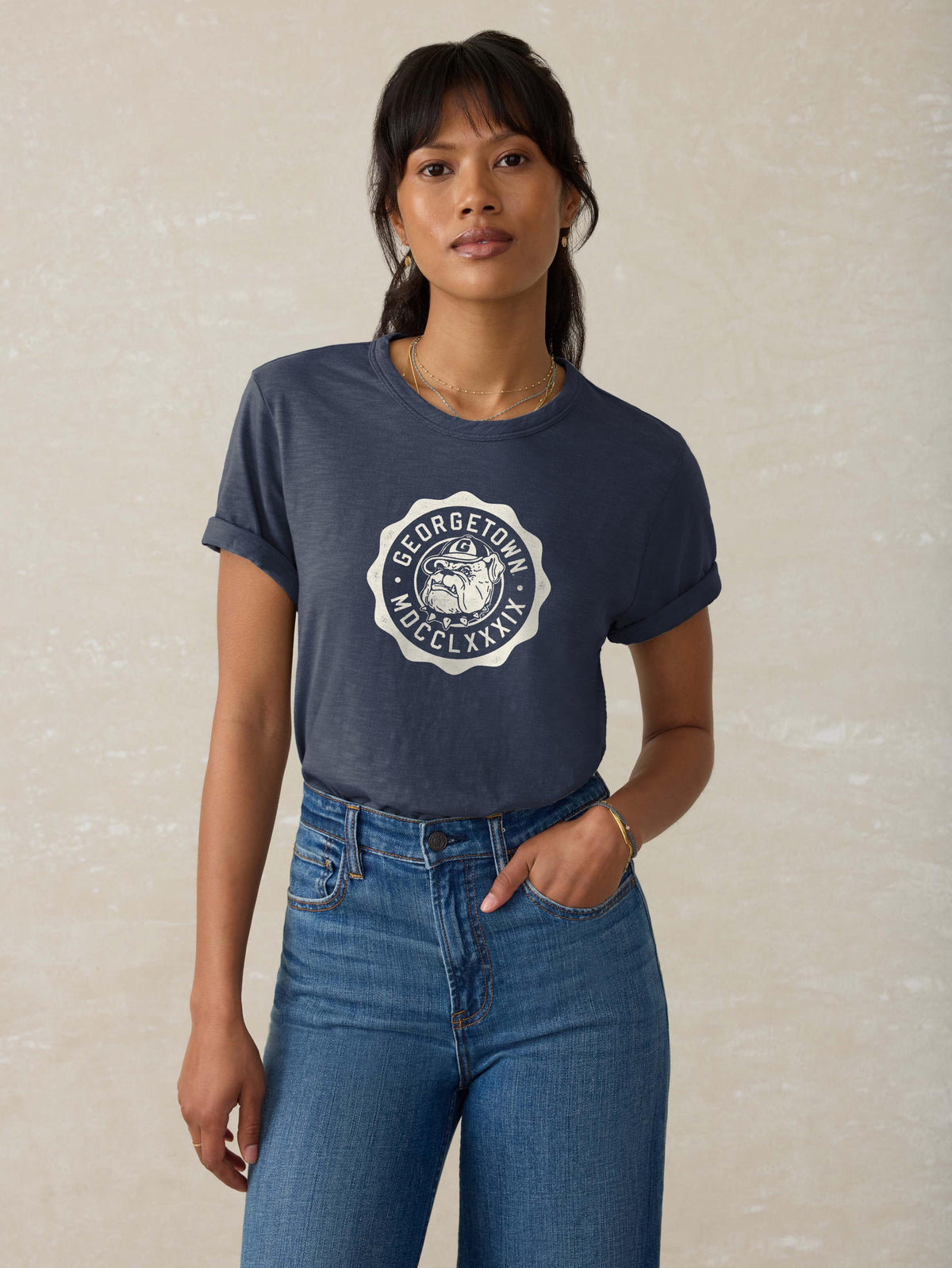 A woman wearing a blue Georgetown tee and blue jeans, image 1 of 1