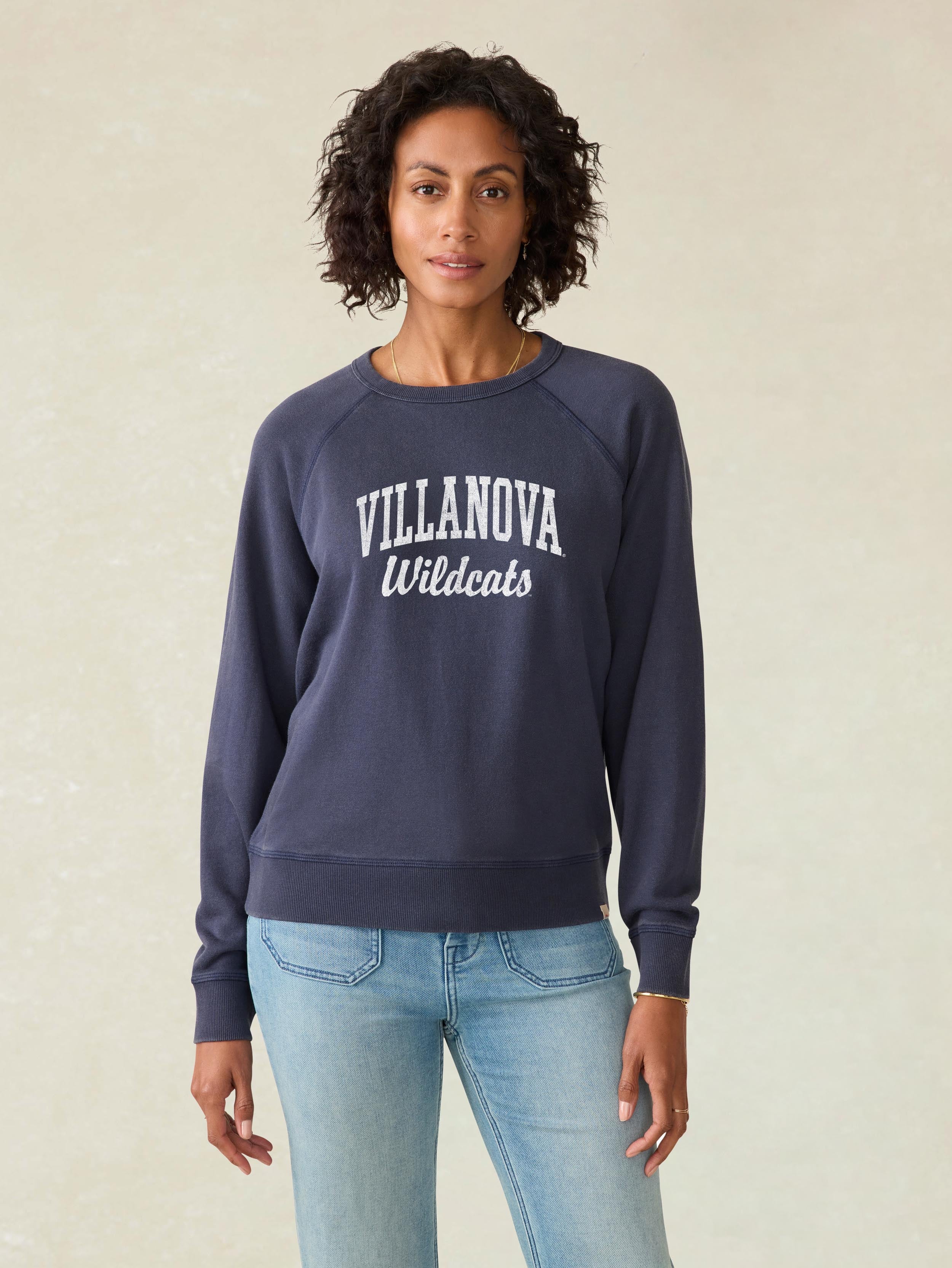 A woman wearing a blue Villanova crewneck and blue jeans