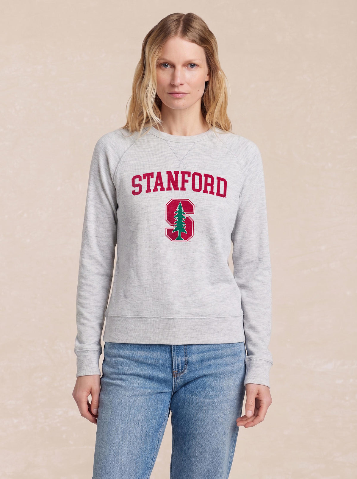 A woman wearing a grey Stanford crewneck and blue jeans, image 1 of 1