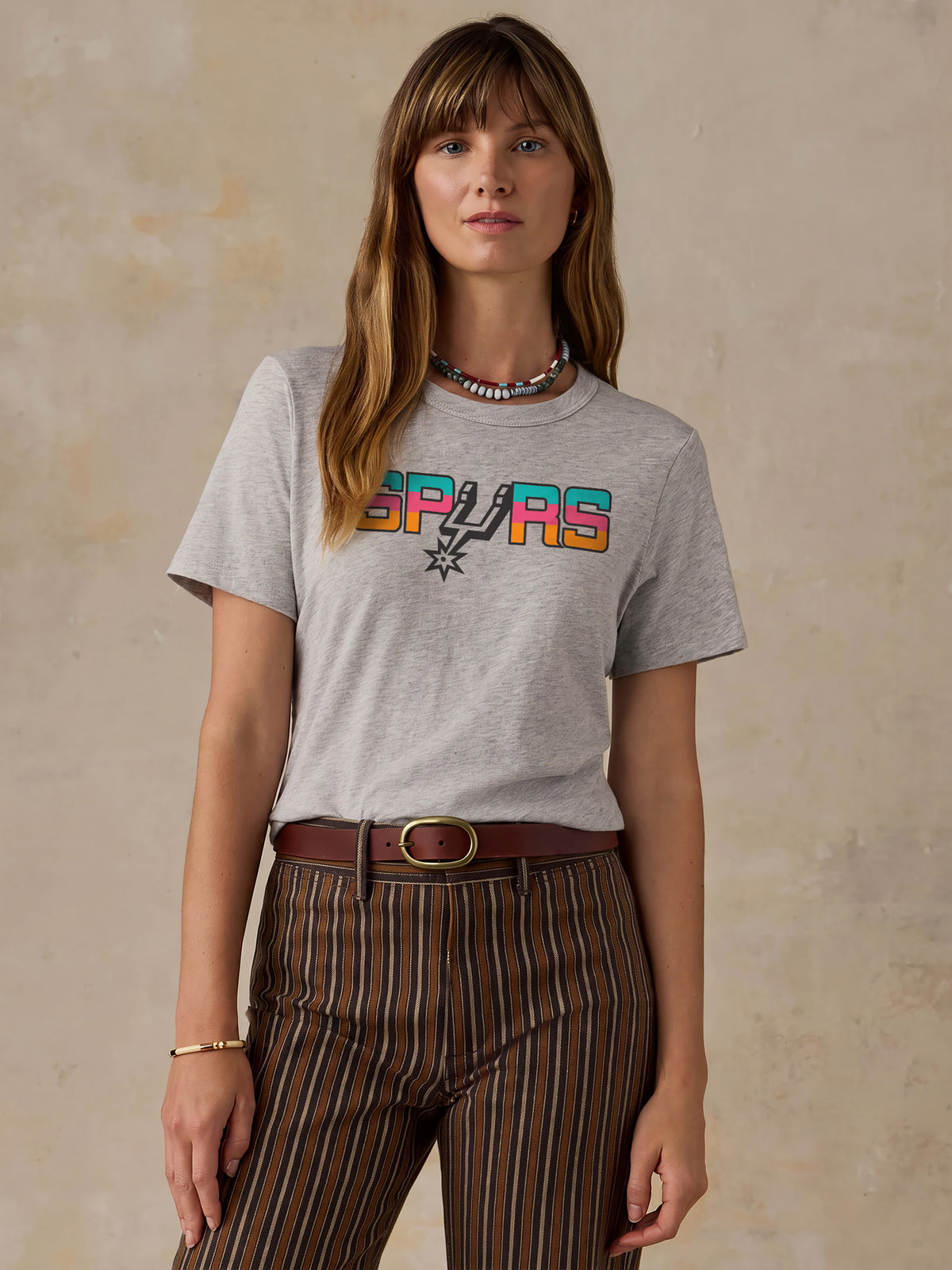 A woman wearing a grey San Antonio Spurs tee, image 1 of 4