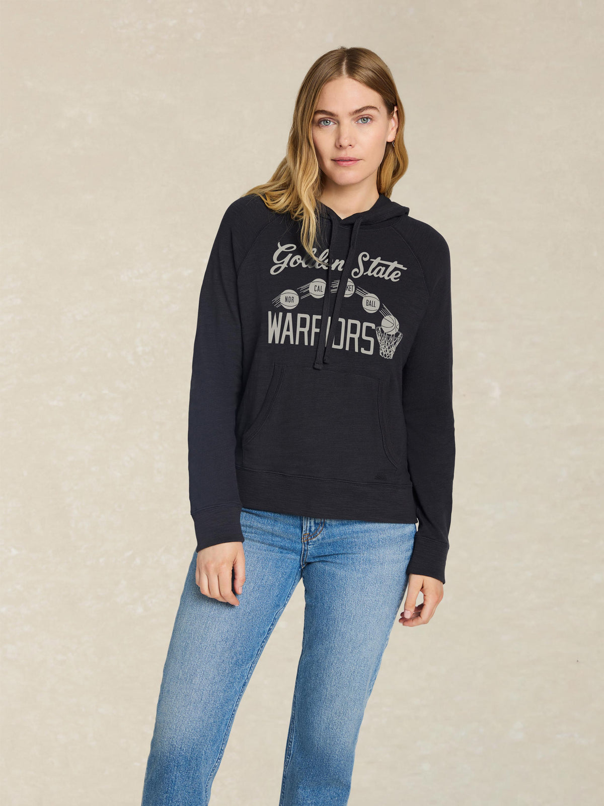 A woman wearing a black Golden State Warriors hoodie, image 1 of 2