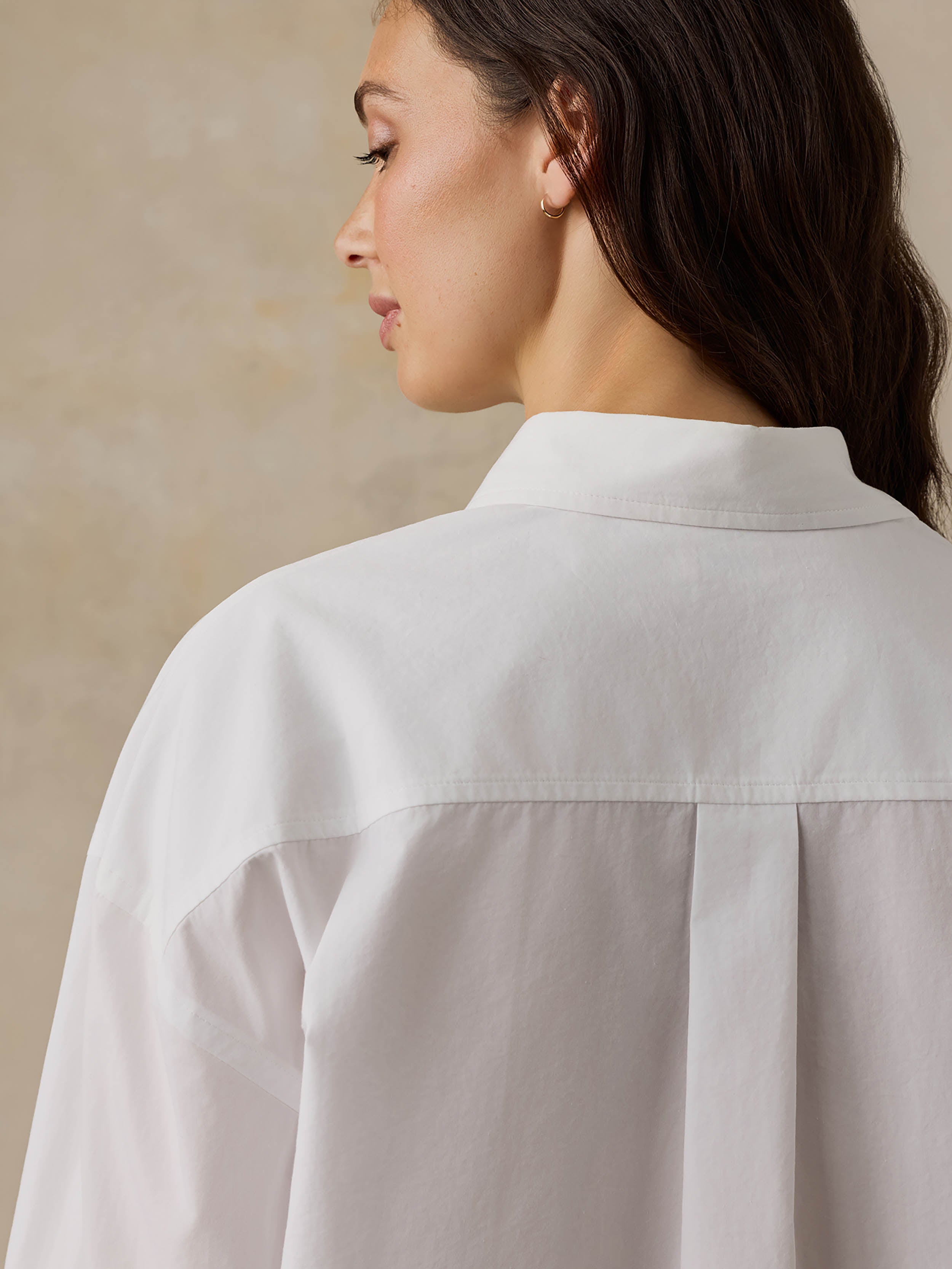 Woman wearing a white shirt against a beige background