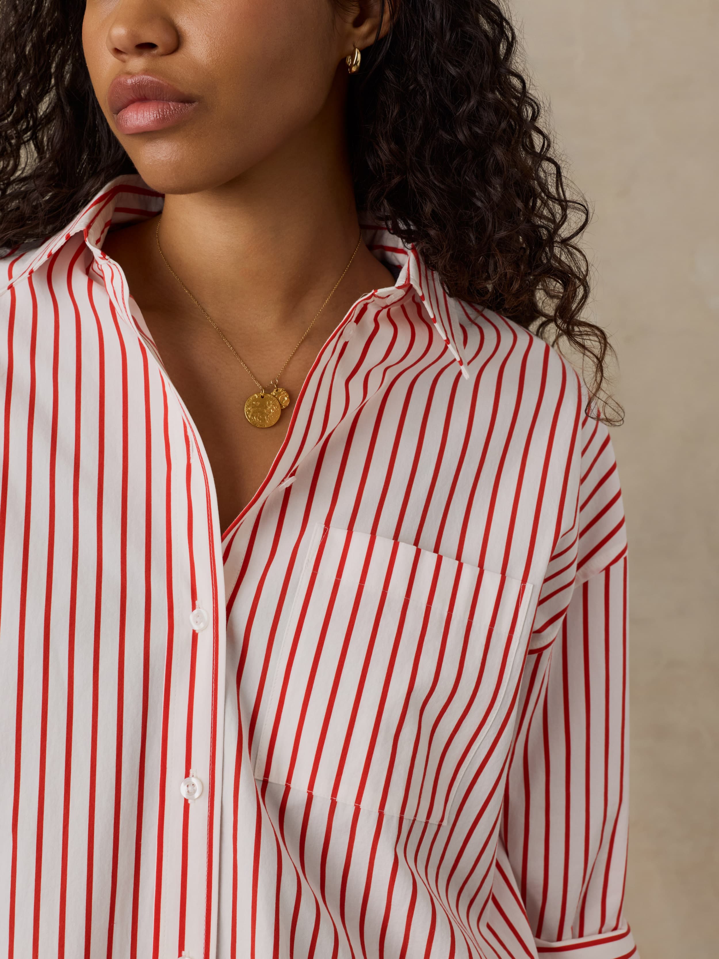 Woman wearing a red and white striped shirt against a beige background