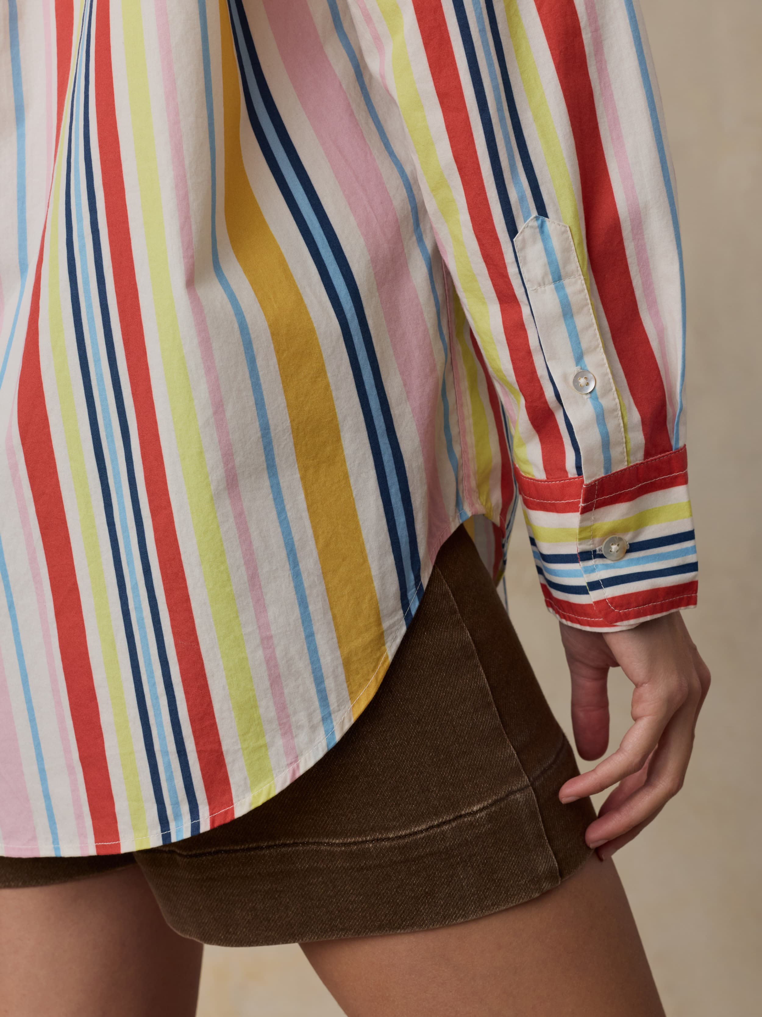 Multicolored striped shirt worn by a person with a neutral background