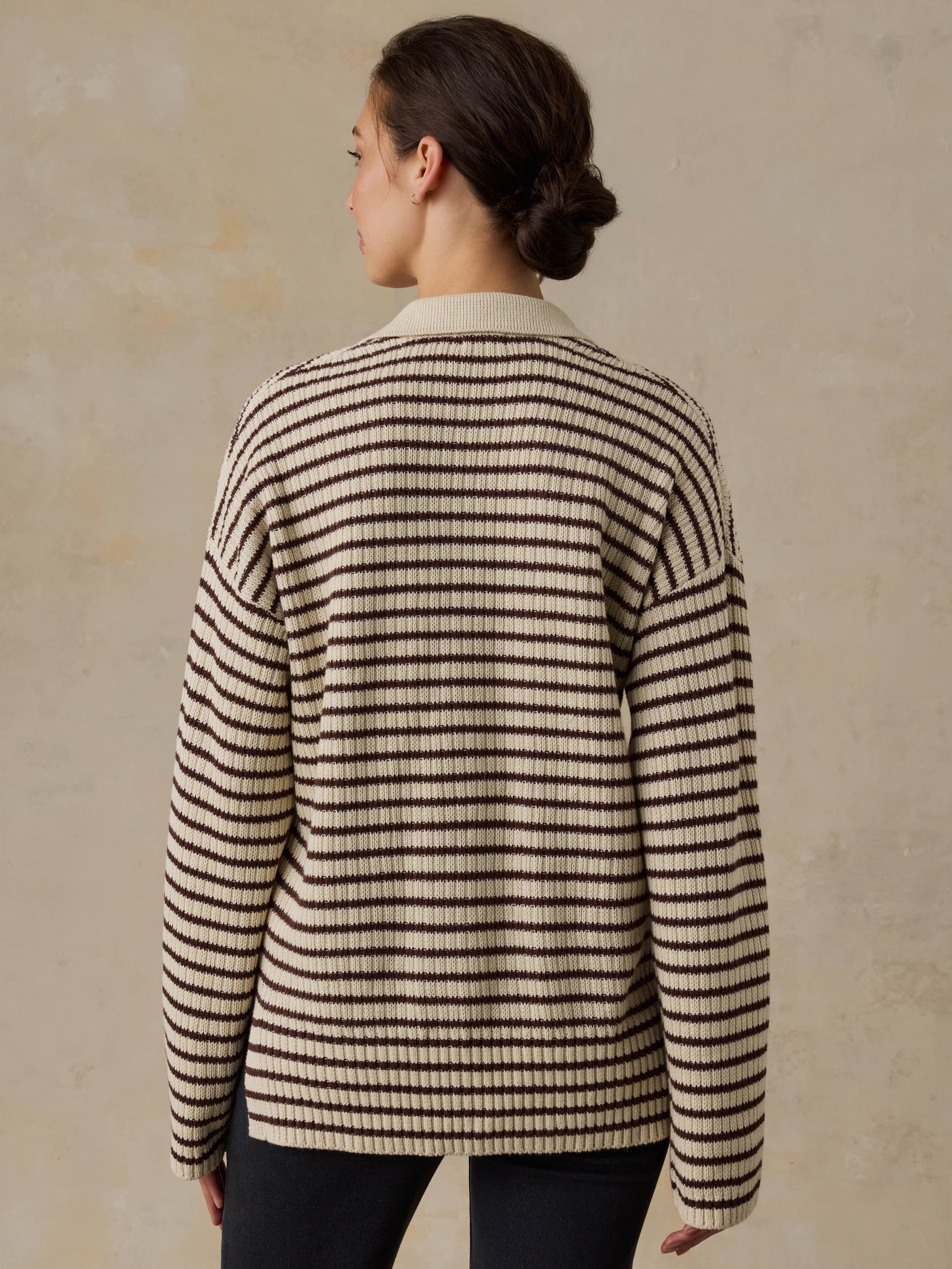 Woman wearing a striped sweater against a beige background