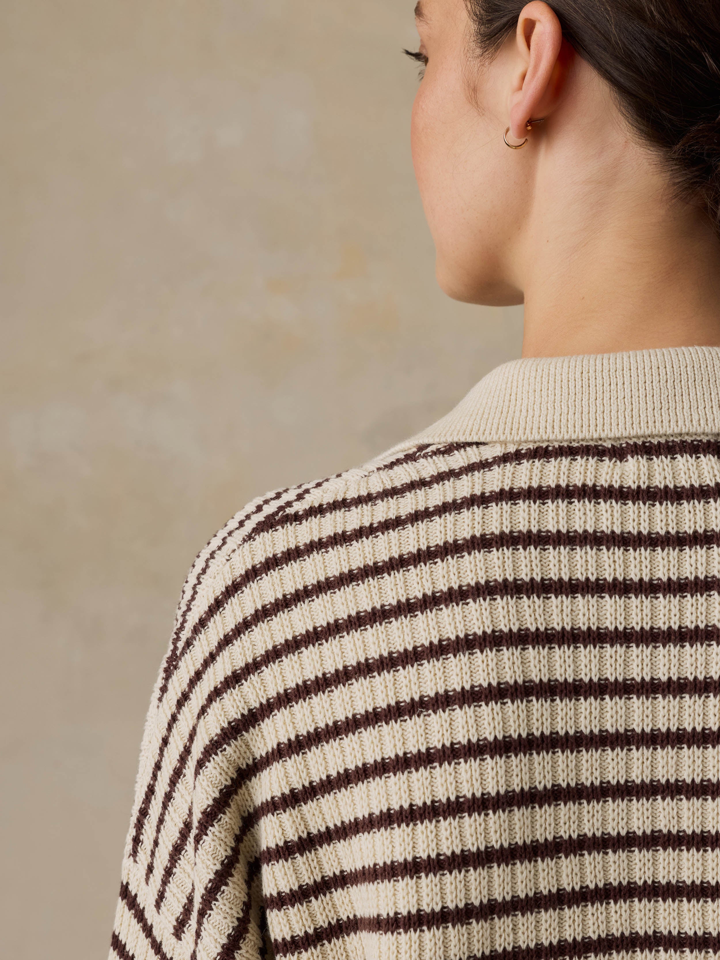 Woman wearing a striped sweater with a beige background