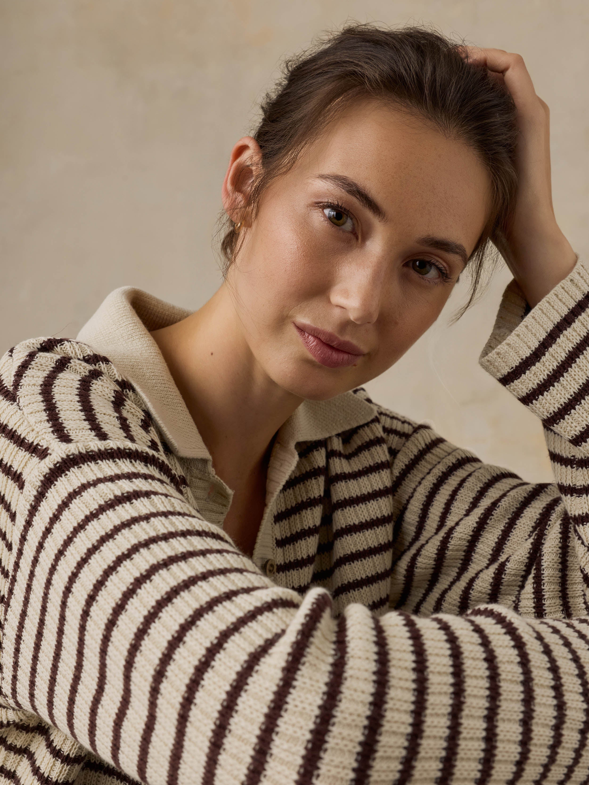Woman wearing a striped sweater against a neutral background