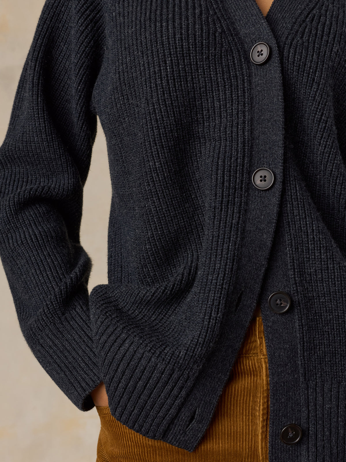 Close-up of a dark charcoal gray ribbed knit cardigan with dark buttons, image 3 of 6