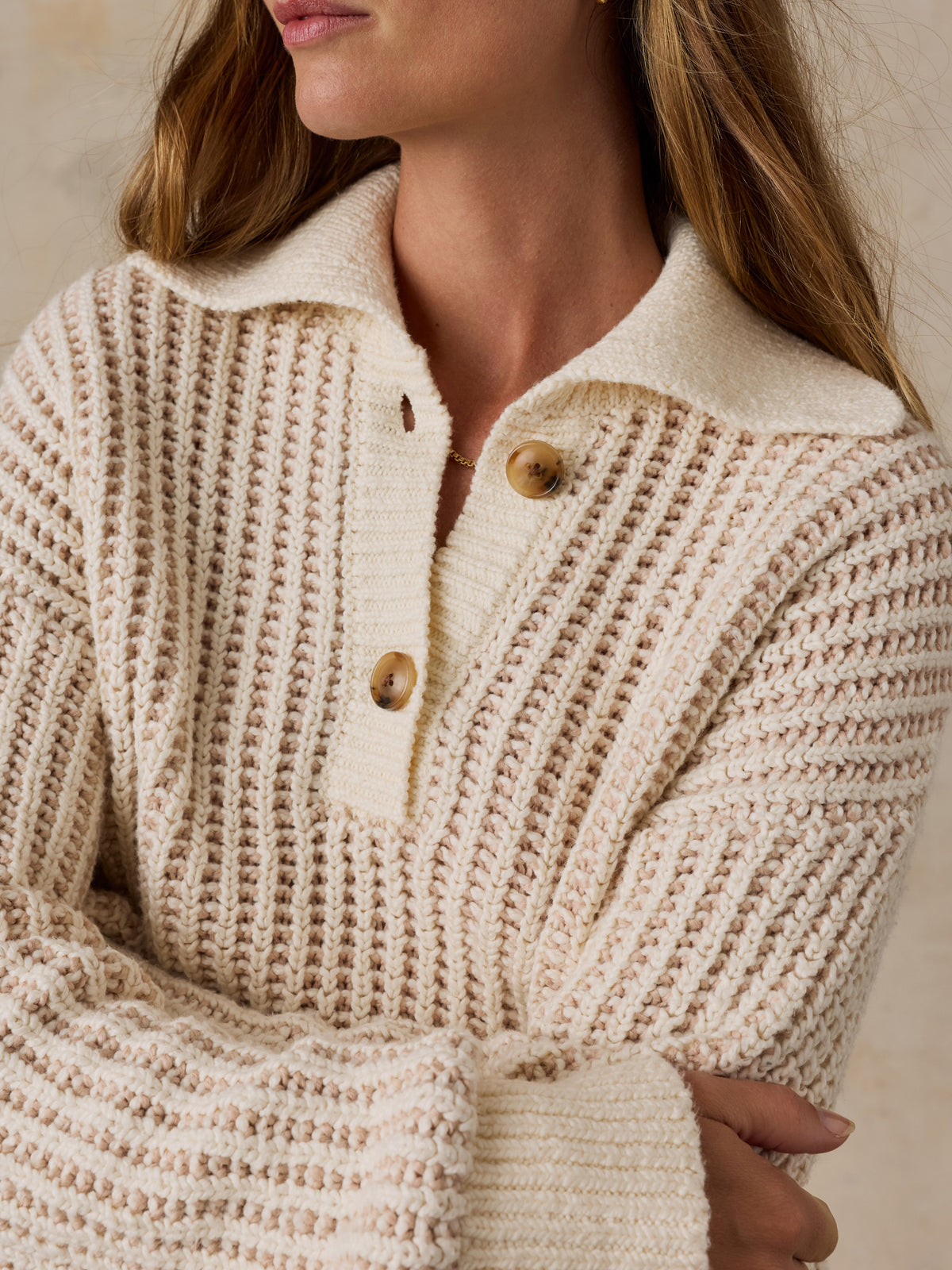 A woman wearing a cream-colored waffle-knit polo sweater, image 4 of 5