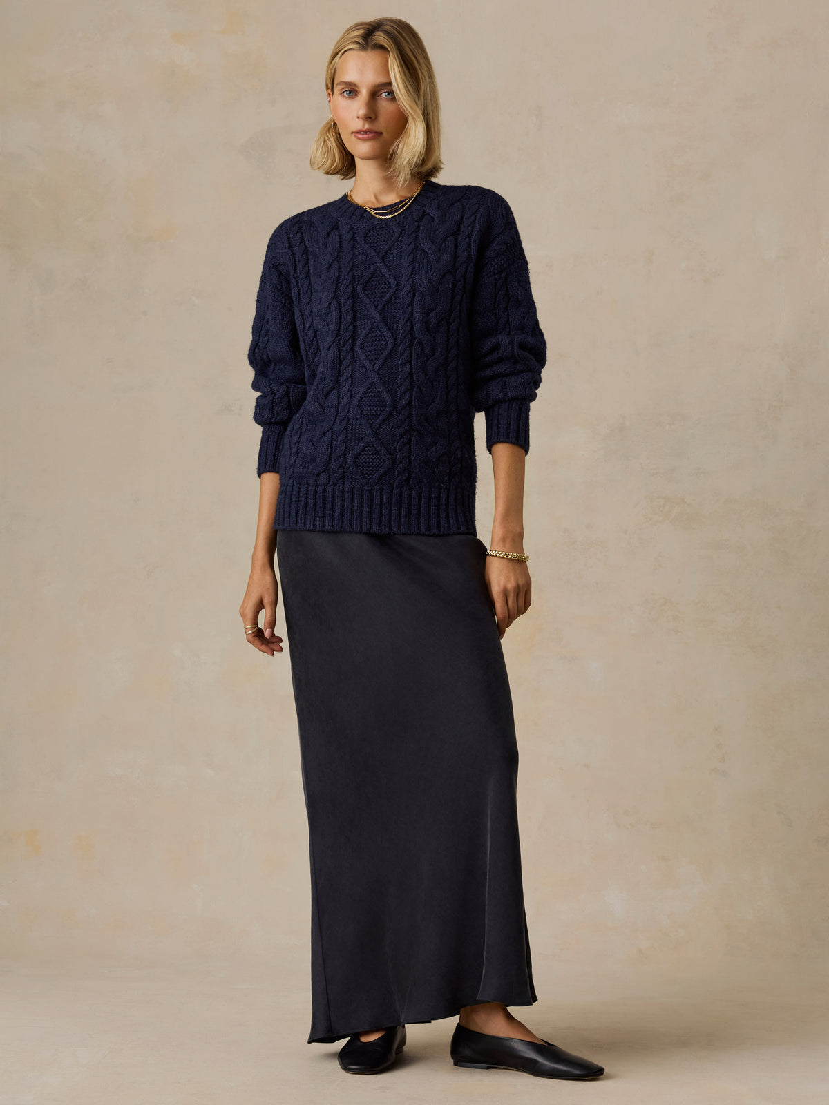 A woman wearing a blue sweater and black skirt, image 5 of 5