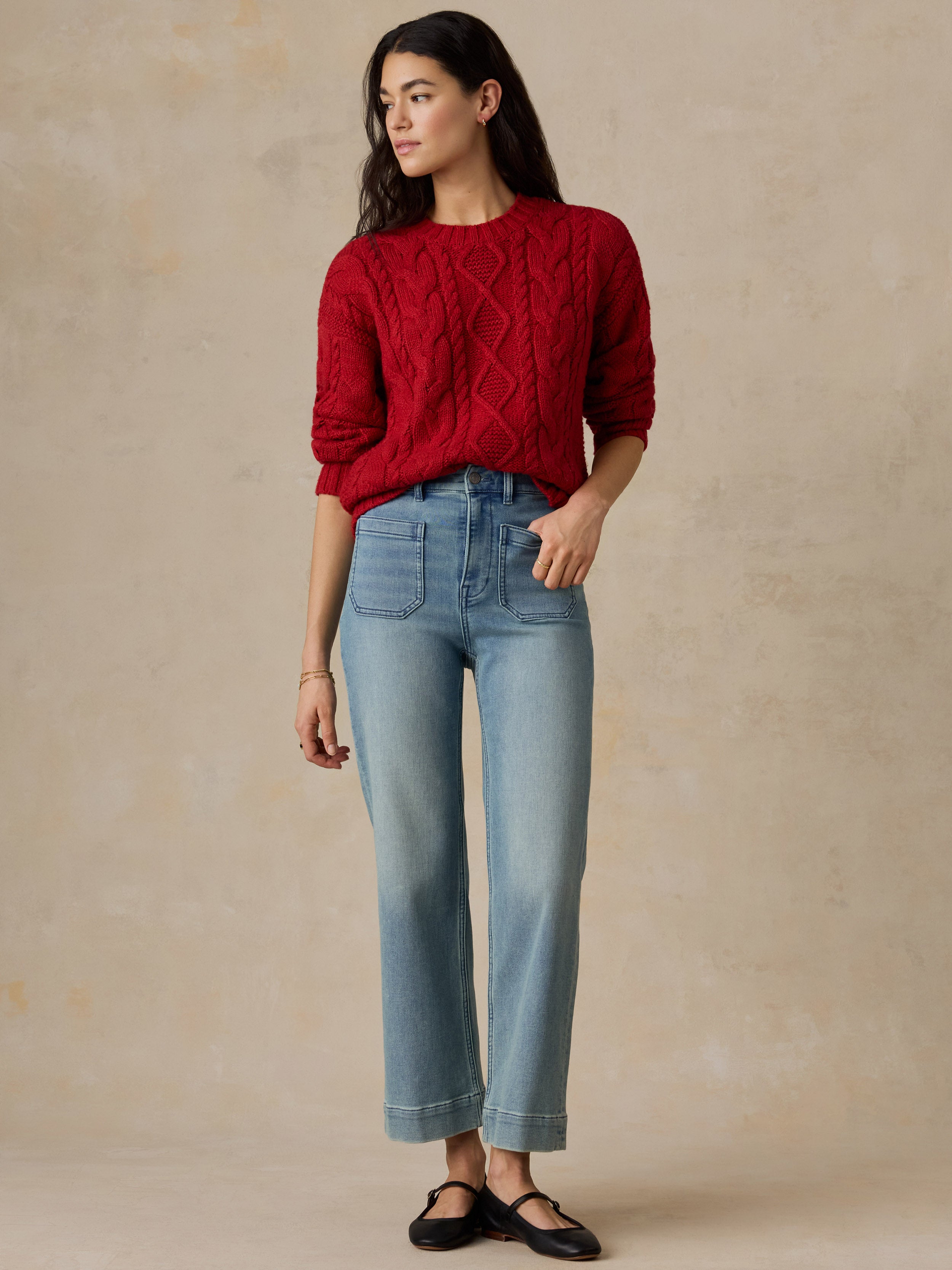 A woman wearing a red sweater and jeans