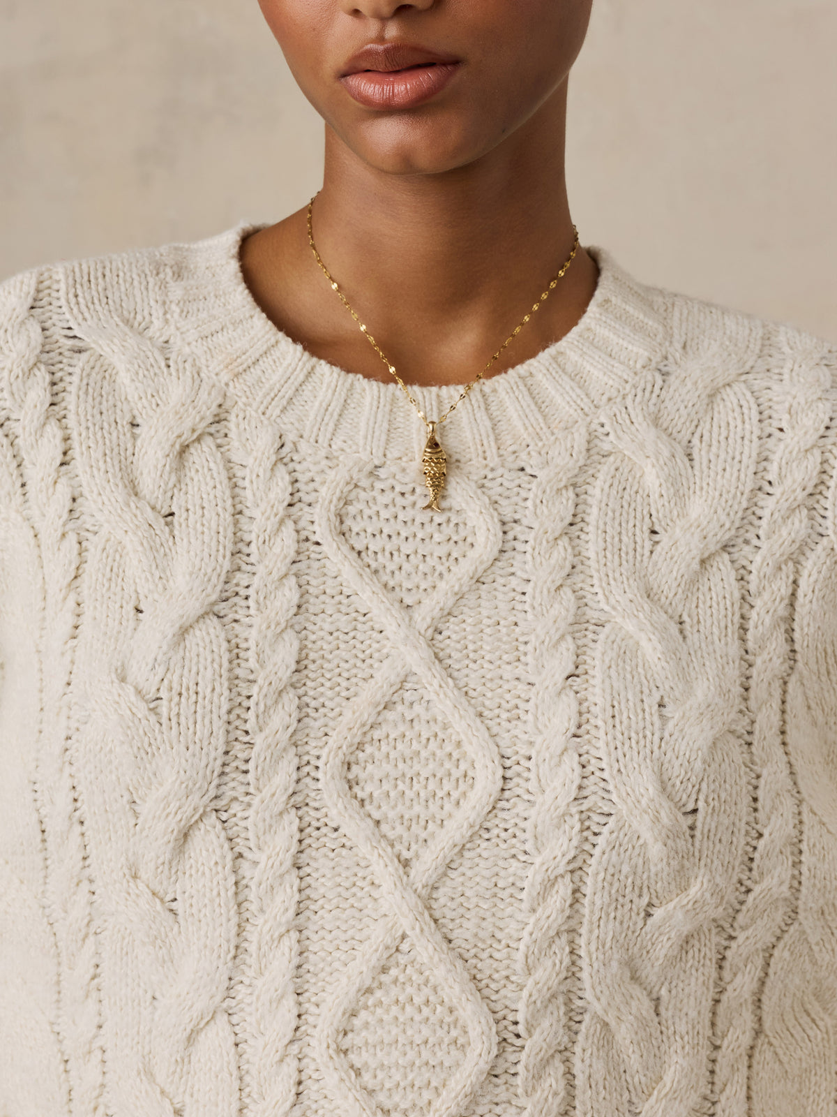 Close up of a woman wearing a white sweater, image 4 of 5