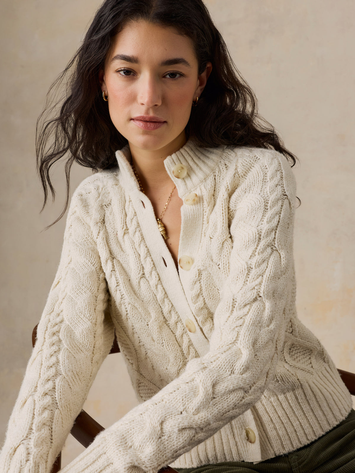 Close up of a woman wearing a cream cardigan, image 5 of 7