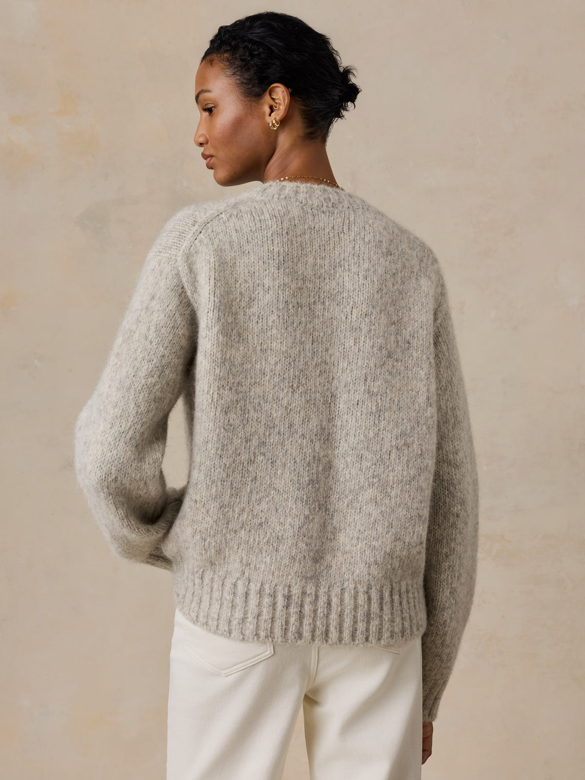 A woman viewed from behind wearing a grey Penguin sweater, image 5 of 5