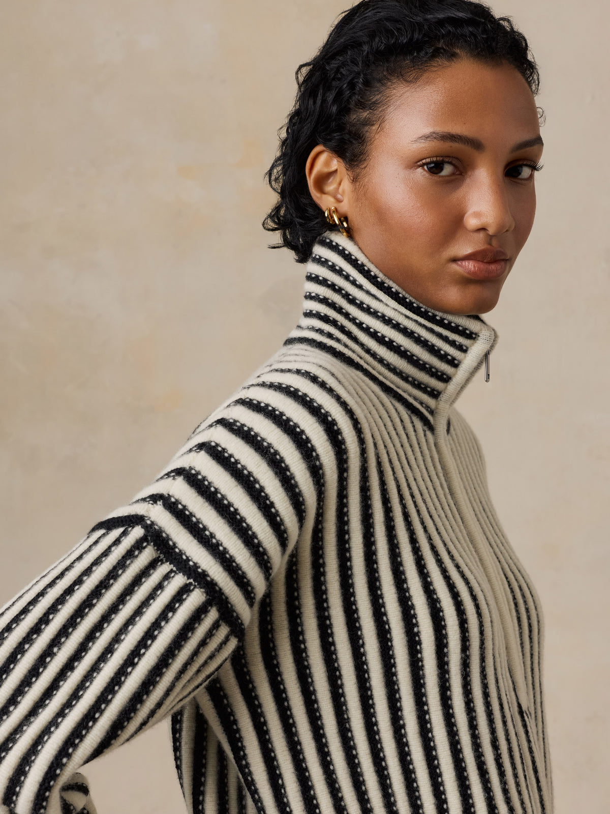 Close up of a woman wearing a black and white striped sweater, image 3 of 5