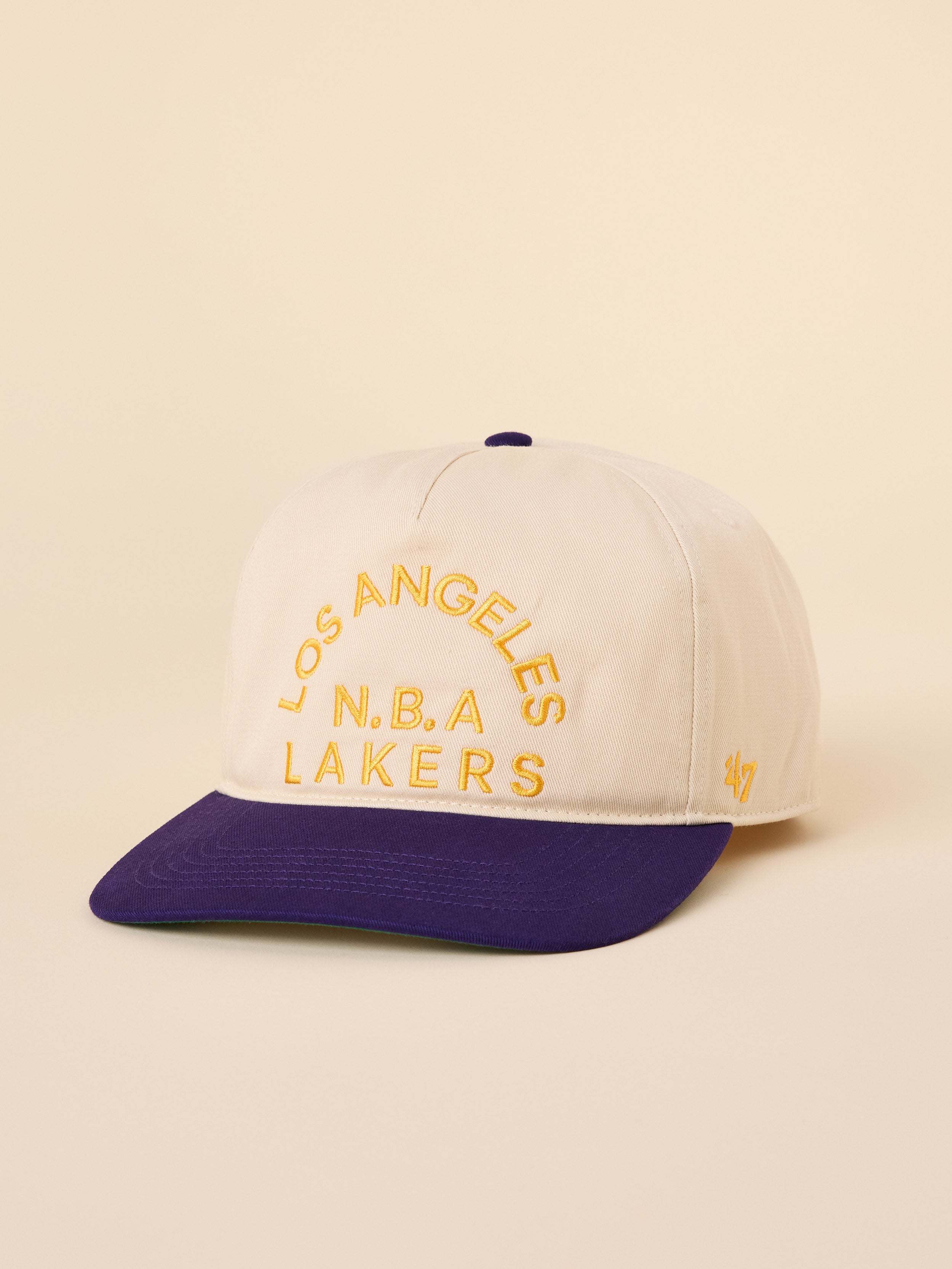 A beige and purple LA Lakers hat