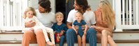 Family photo with kids and parents on porch steps wearing pajamas.