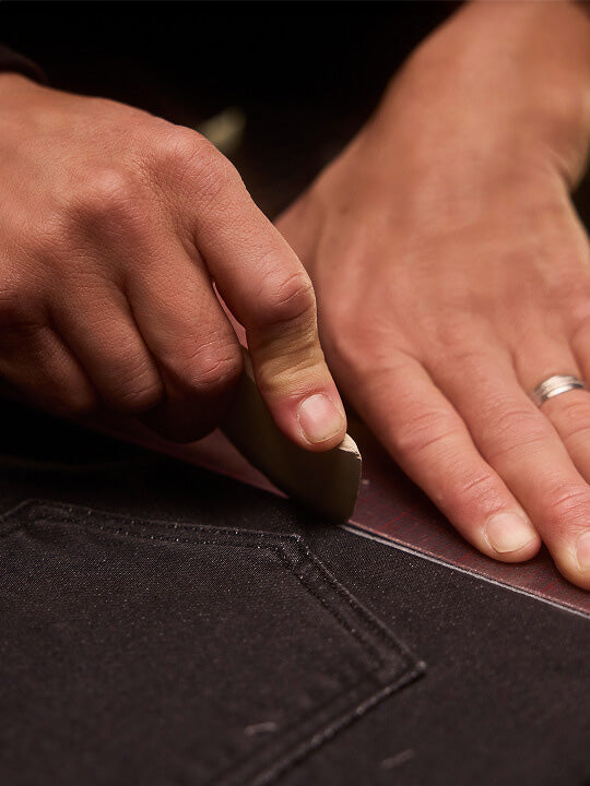 Close up shot of hands scoring stretch terry fabric before cutting 