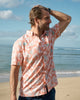 Man standing on the shoreline at the beach in Hawaii wearing the Breeze Shirt.