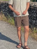 Man wearing a floral patterned shirt and brown linen shorts walking outside